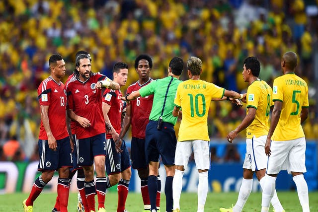 Referee Carlos Velasco Carballo separates Colombia's James Rodriguez and Paulinho of Brazil