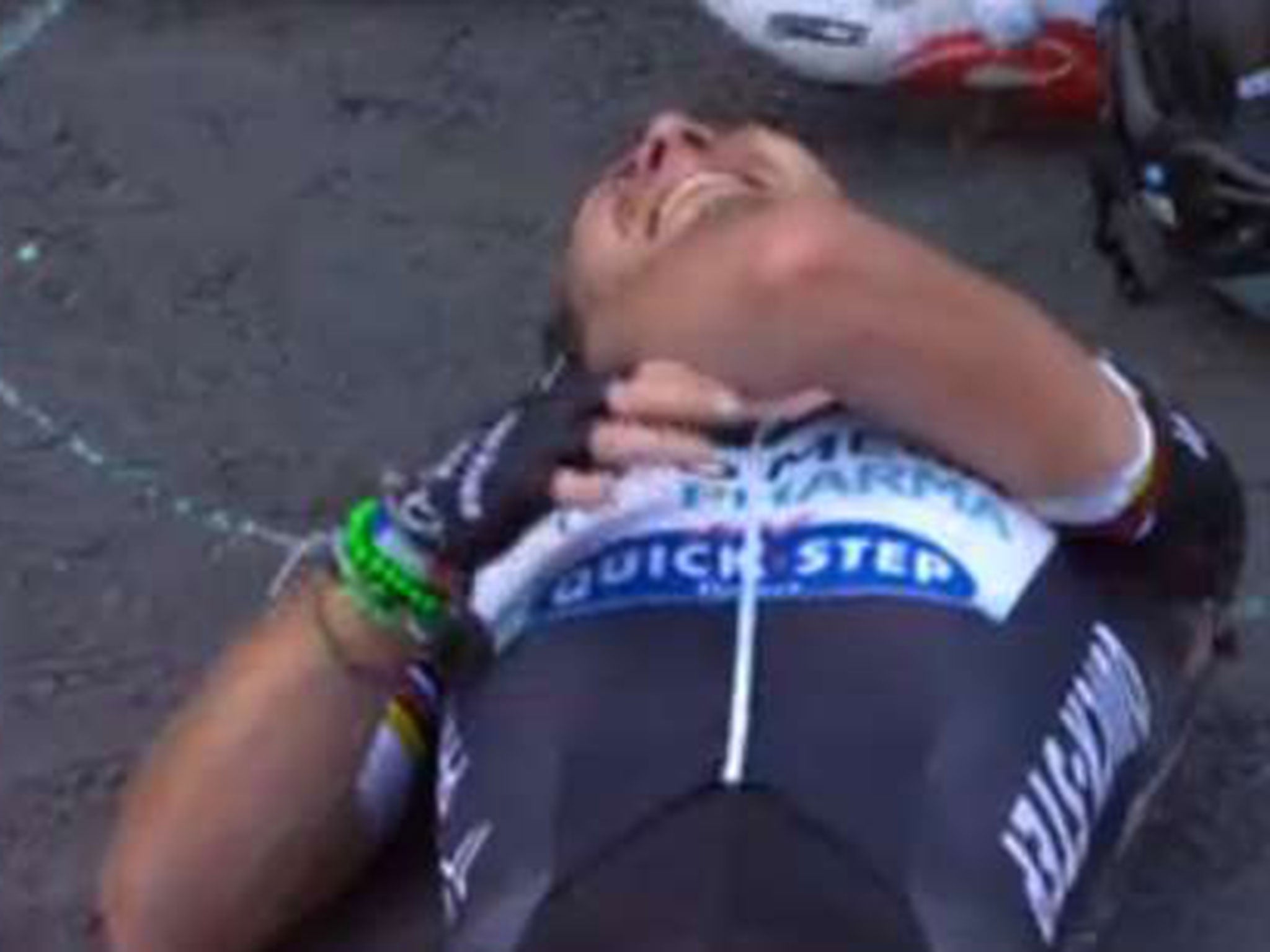 Mark Cavendish holds his collarbone as he is clearly in pain