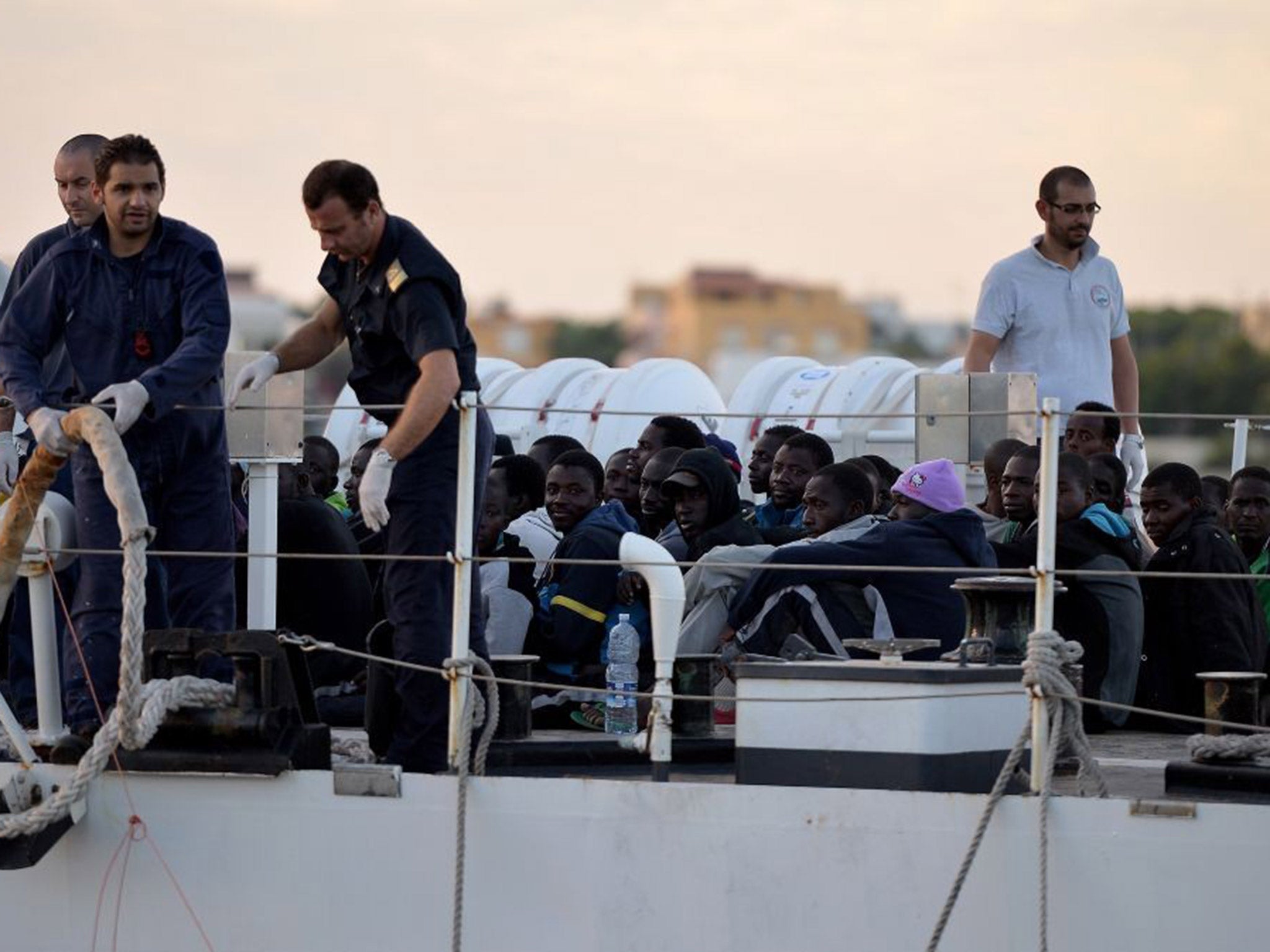 Some 100 migrants sit on the Guardia Costiera boat after being rescued off the shores of the island of Lampedusa last year