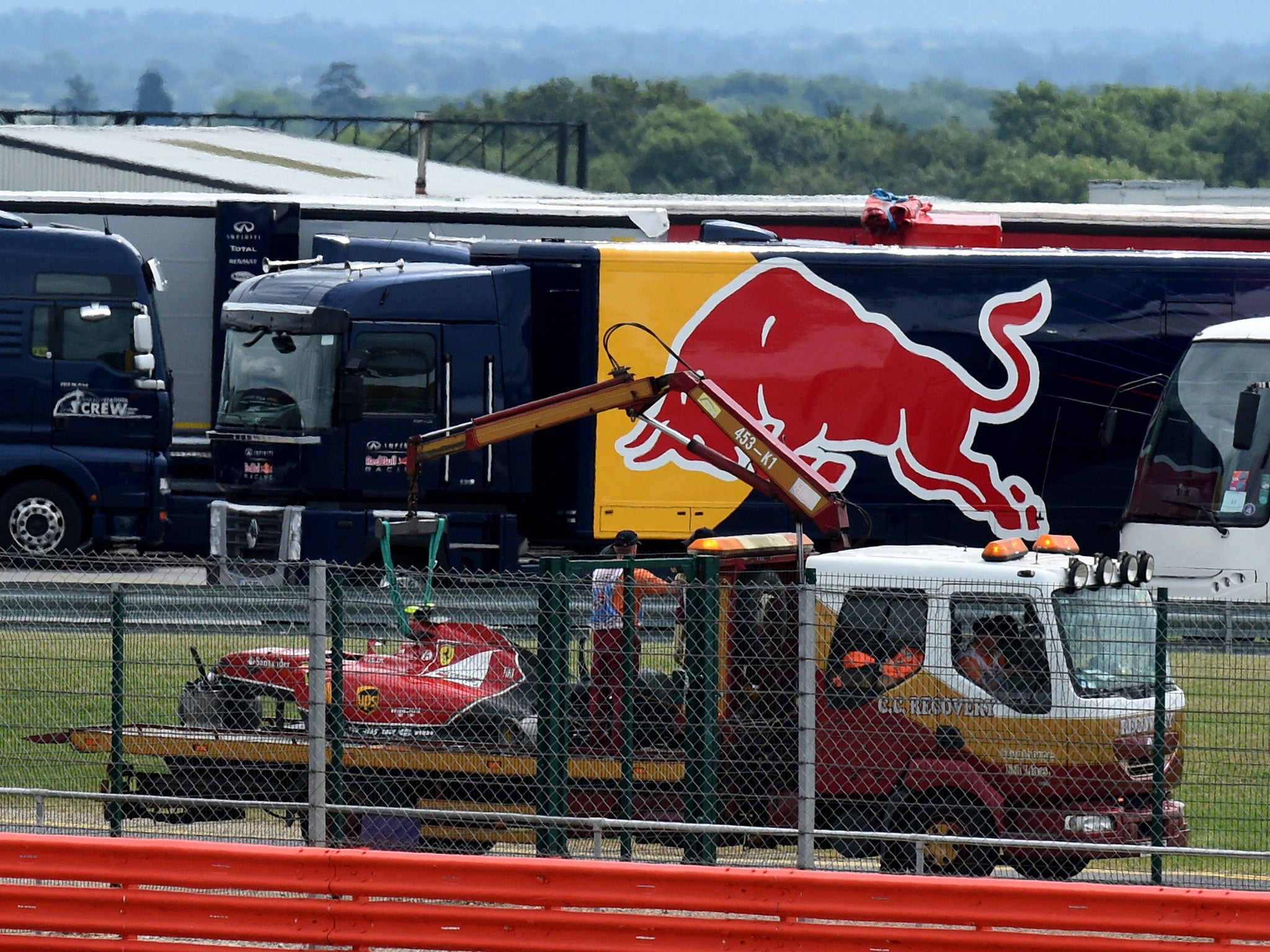 Kimi Raikkonen's heavily damaged Ferrari is taken back to the Silverstone paddock