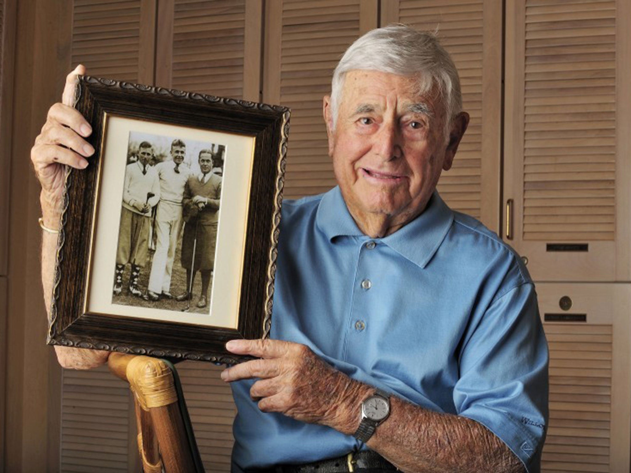 Portrait of Errie Ball at Willoughby GC. Ball holding photograph of (L-R) himself, Charlie Yates and Bob Jones.