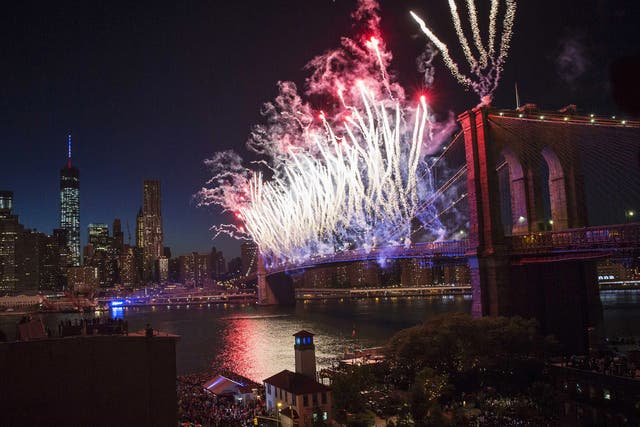 Fireworks explode over the Brooklyn Bridge and the East River in New York City
