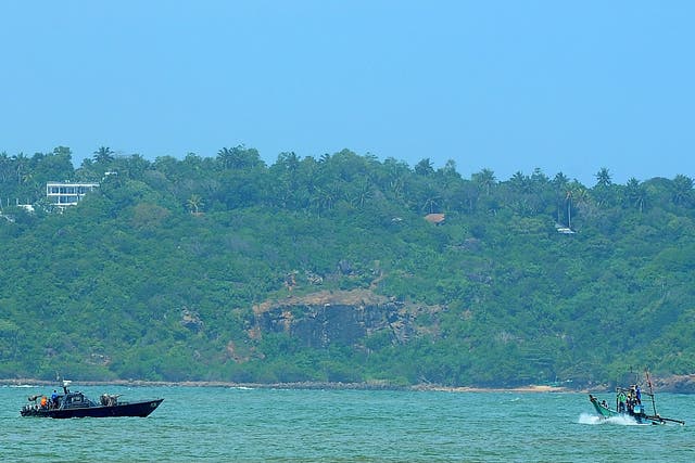 A Sri Lankan navy boat (L) patrols after Sri Lanka transfered 41 would-be asylum seekers whose boat was turned away by Australia at the southern port of Galle 