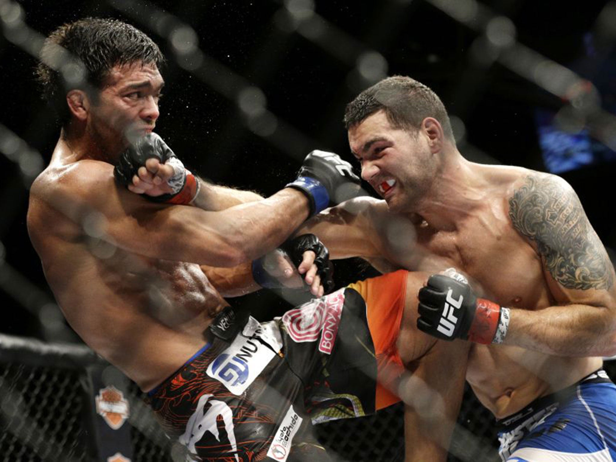 Chris Weidman (right) hits Lyoto Machida during their mixed martial arts middleweight title bout at UFC 175 Saturday