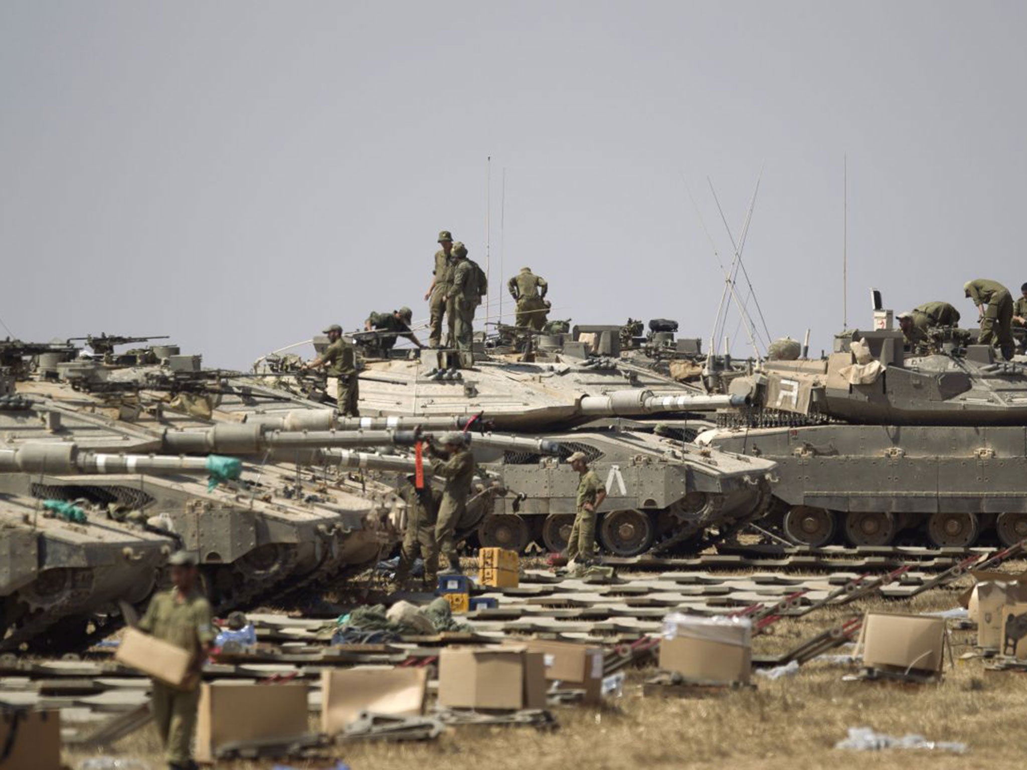 Israeli soldiers working on their tanks near the border with the Gaza Strip