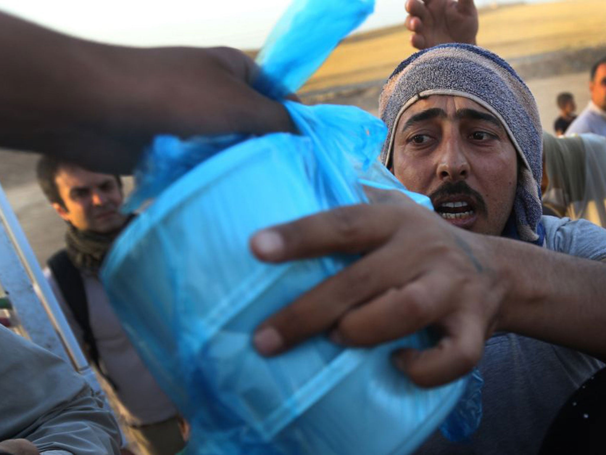 Food being distributed by charities on the first day of Ramadan, at encampments for Iraqis who have fled from Mosul
