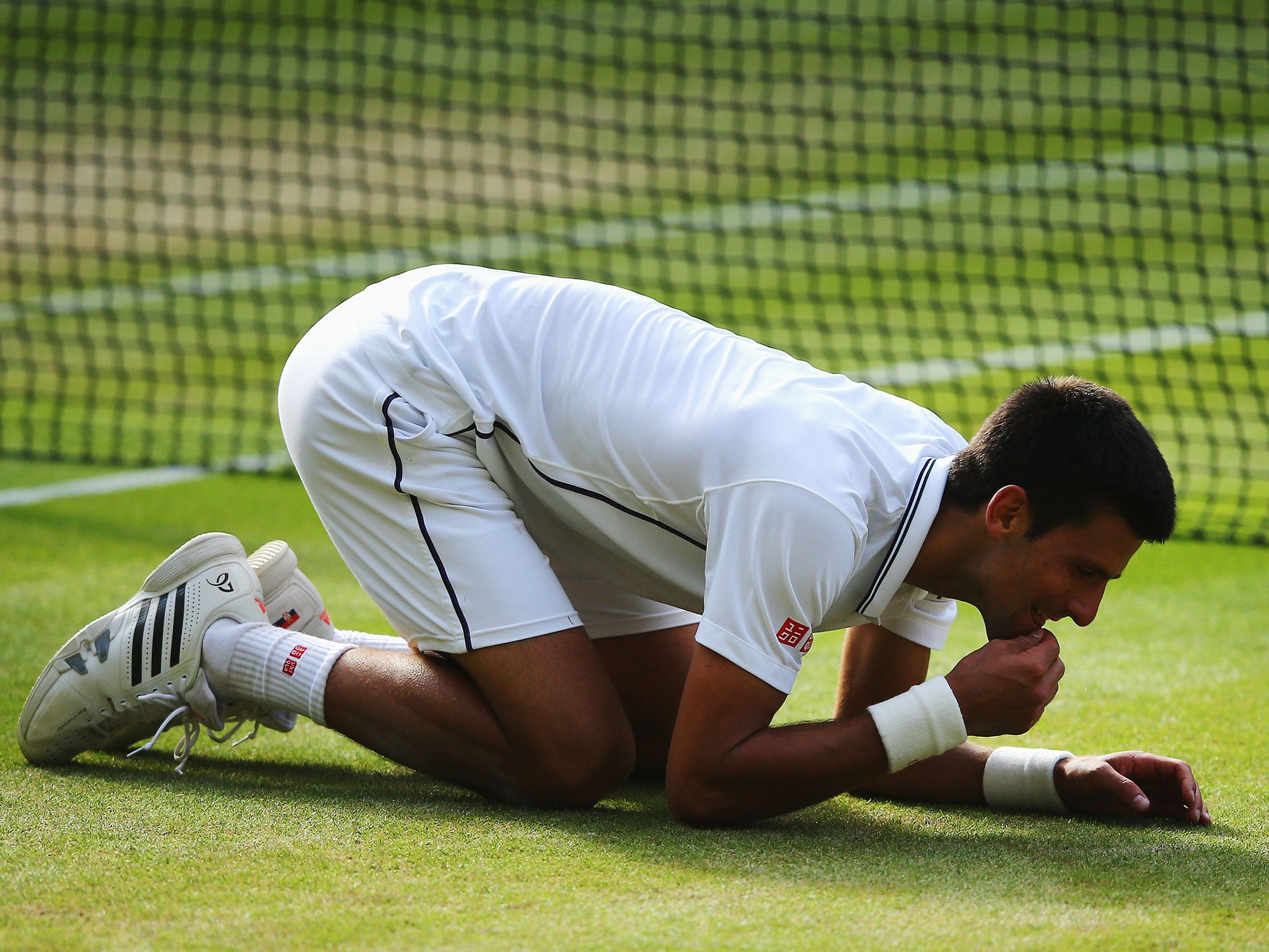 Djokovic ate the grass of Centre Court in celebration after beating Federer (Getty)