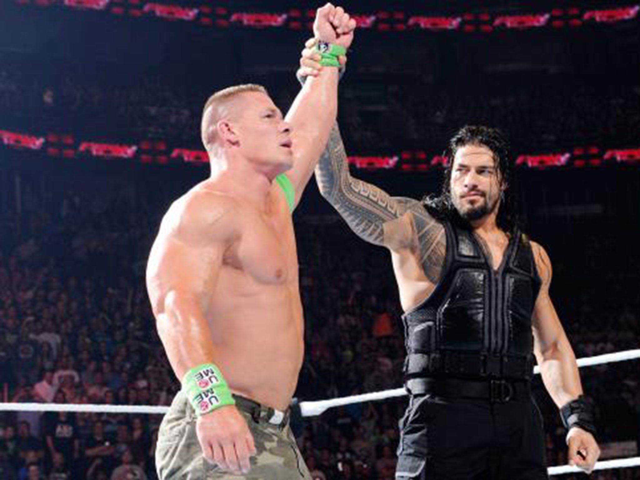 Roman Reigns raises John Cena's arm at the end of Raw