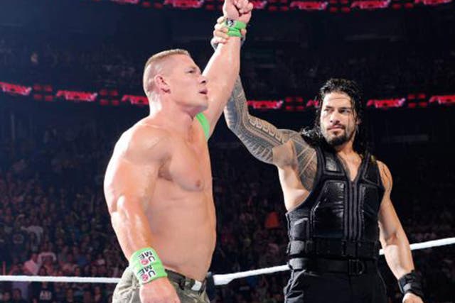 Roman Reigns raises John Cena's arm at the end of Raw