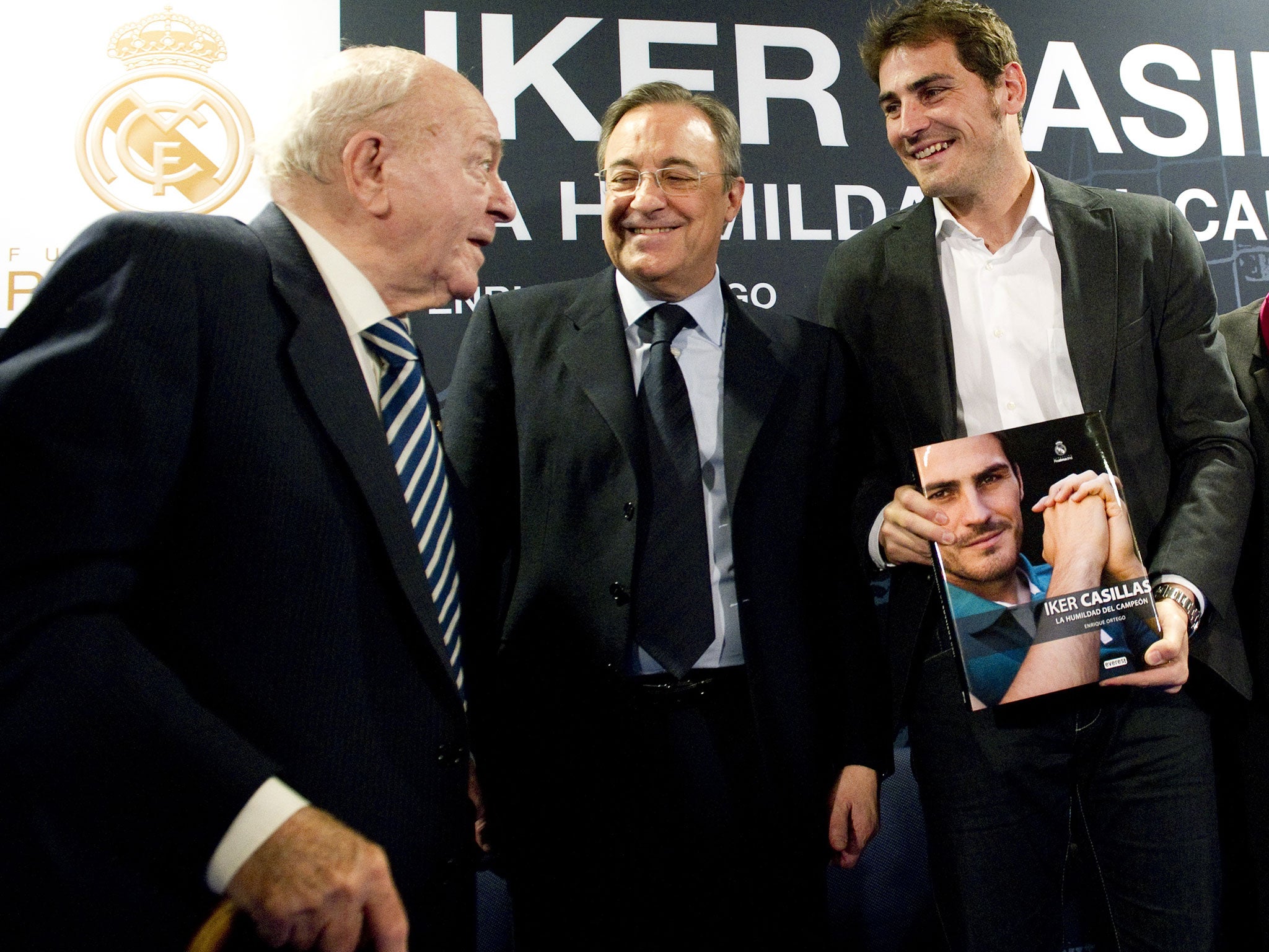 Real Madrid's goalkeeper and captain Iker Casillas (R) poses with his biography 'La humildad del campeon' (The humility of the champion) flanked by President of Real Madrid football club Florentino Perez and President of Honour of Real Madrid Alfredo Di S