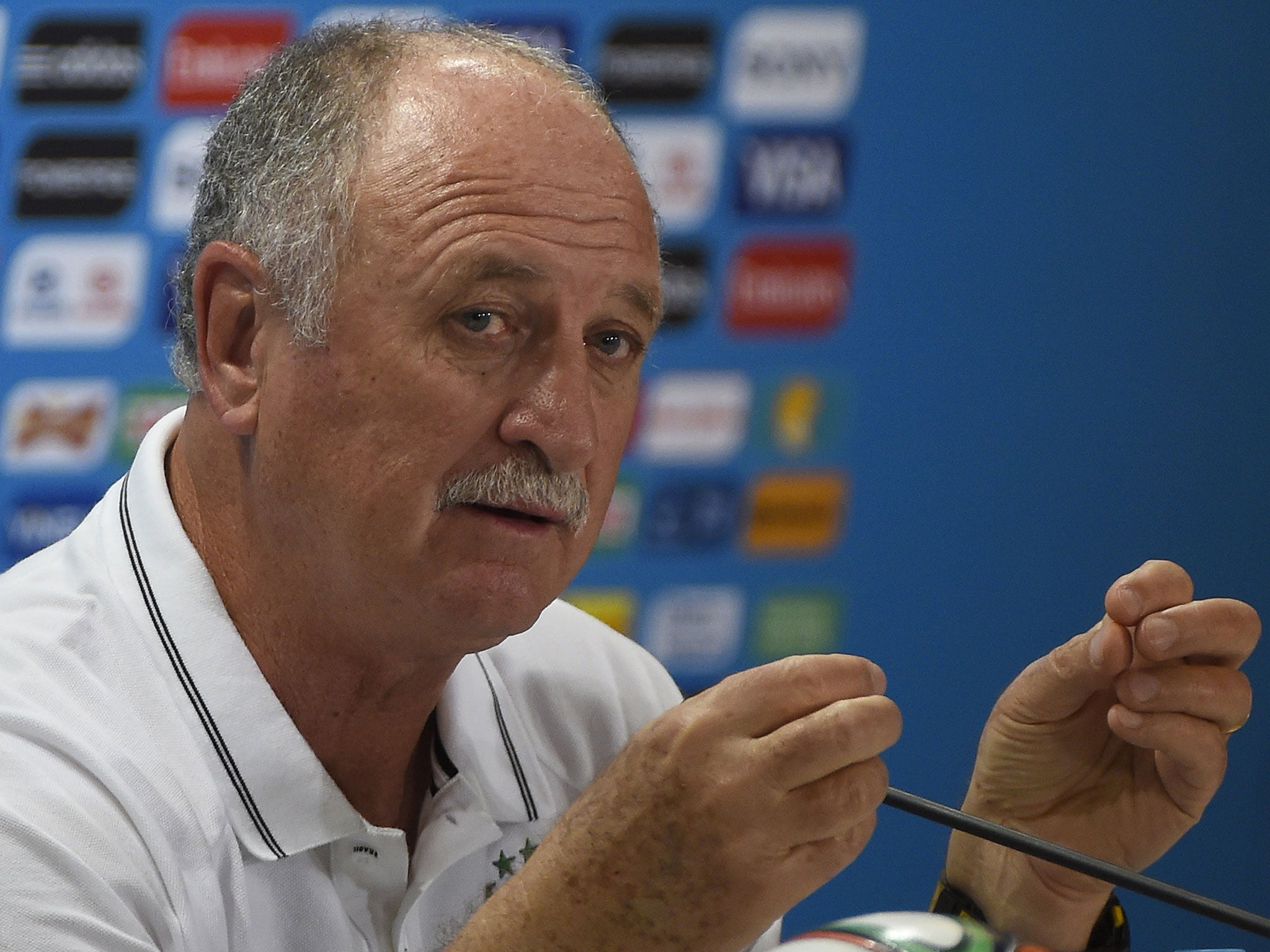 Brazil manager Luis Felipe Scolari does his best attempt to practice lifting the World Cup trophy
