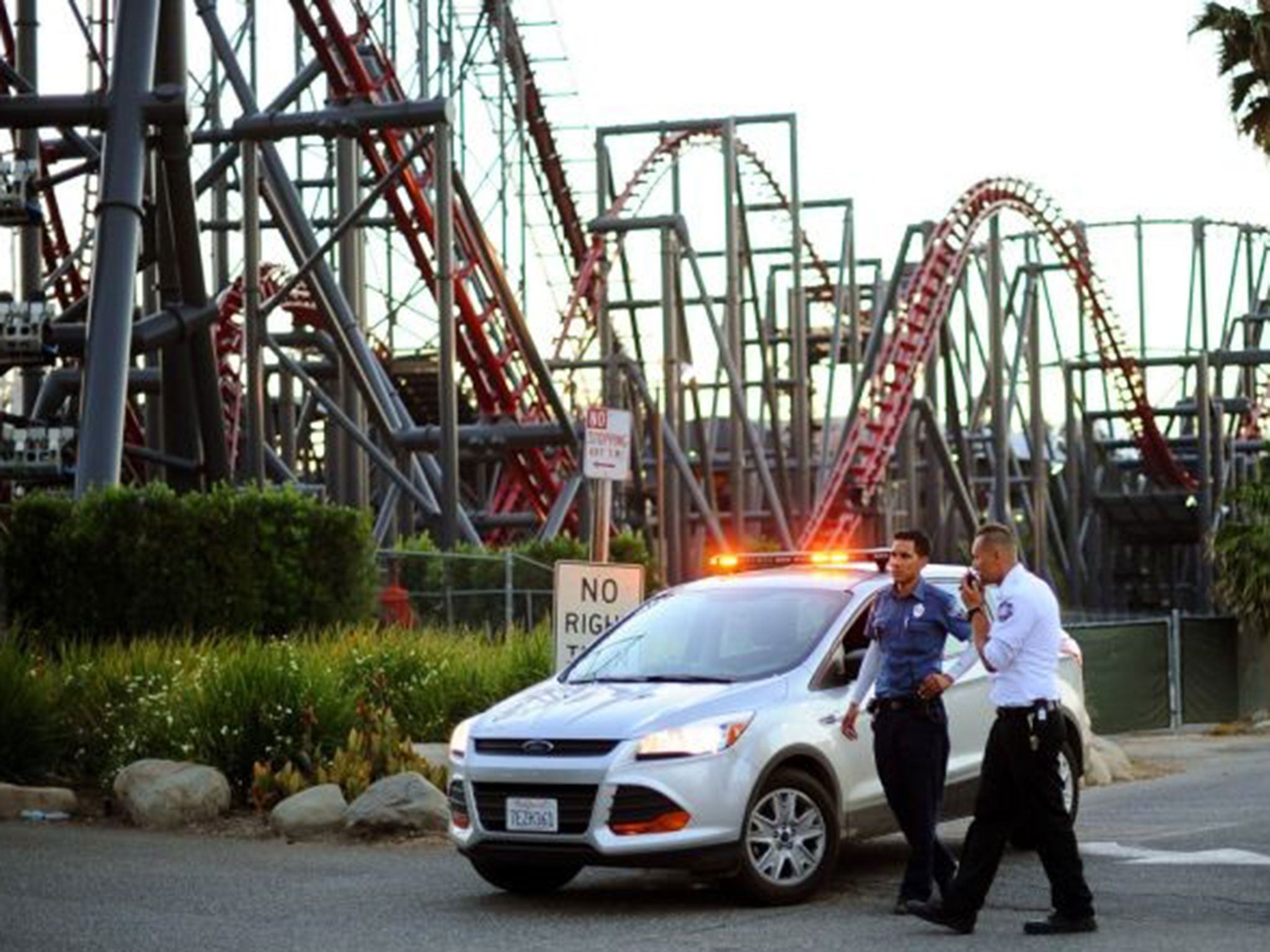 Members of the Six Flags Magic Mountain amusement park security staff monitor the situation at the exit of the park after riders were injured on the Ninja coaster Monday, July 7,