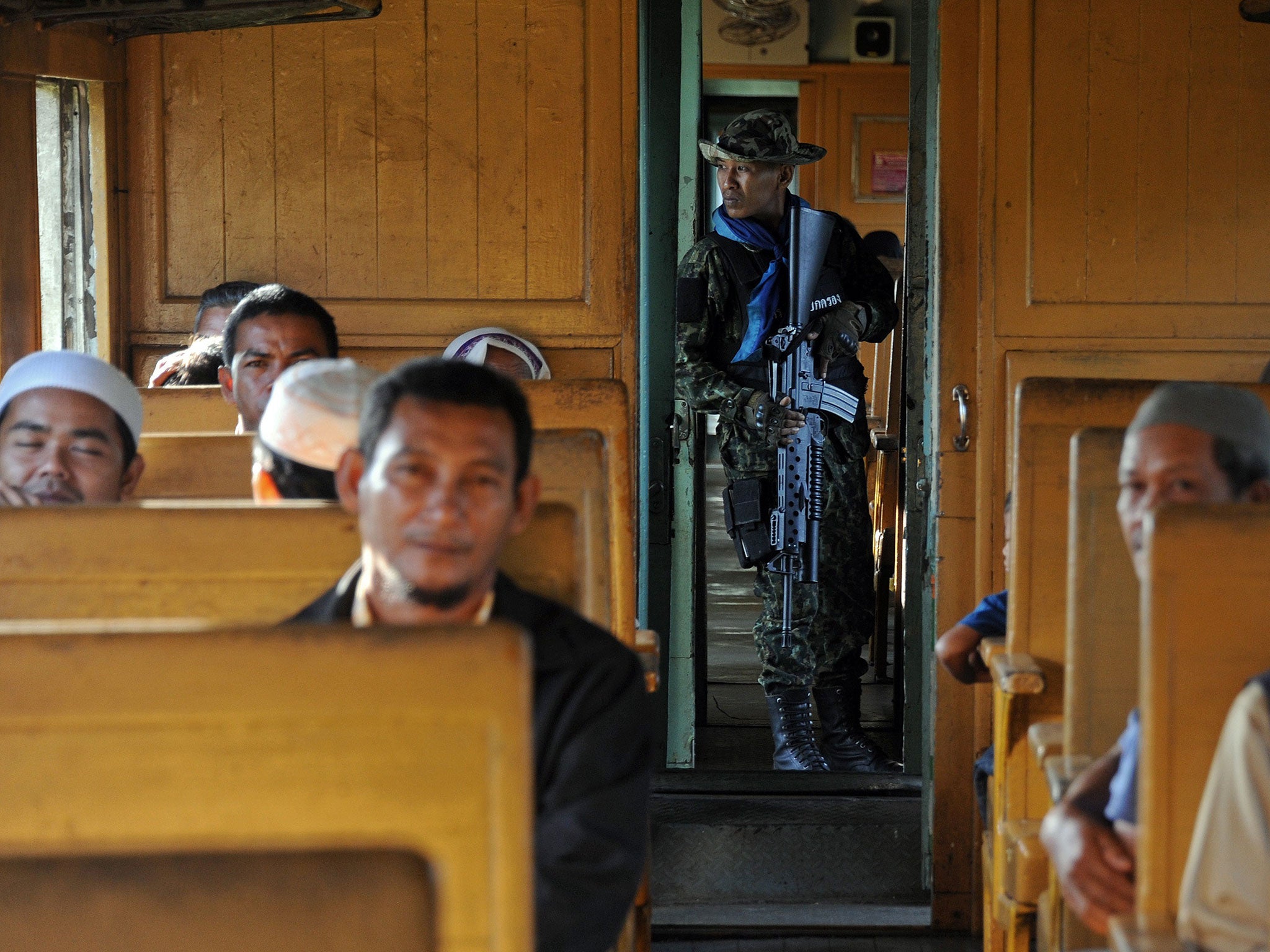 FILE PHOTO: A Thai soldier keeps watch on a train on the southern line to the border town of Sungai Kolok