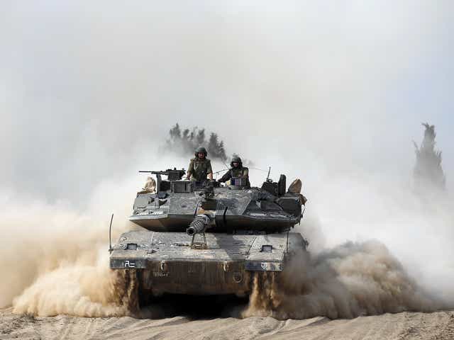 Israeli soldiers ride atop a tank outside the southern Gaza Strip. 