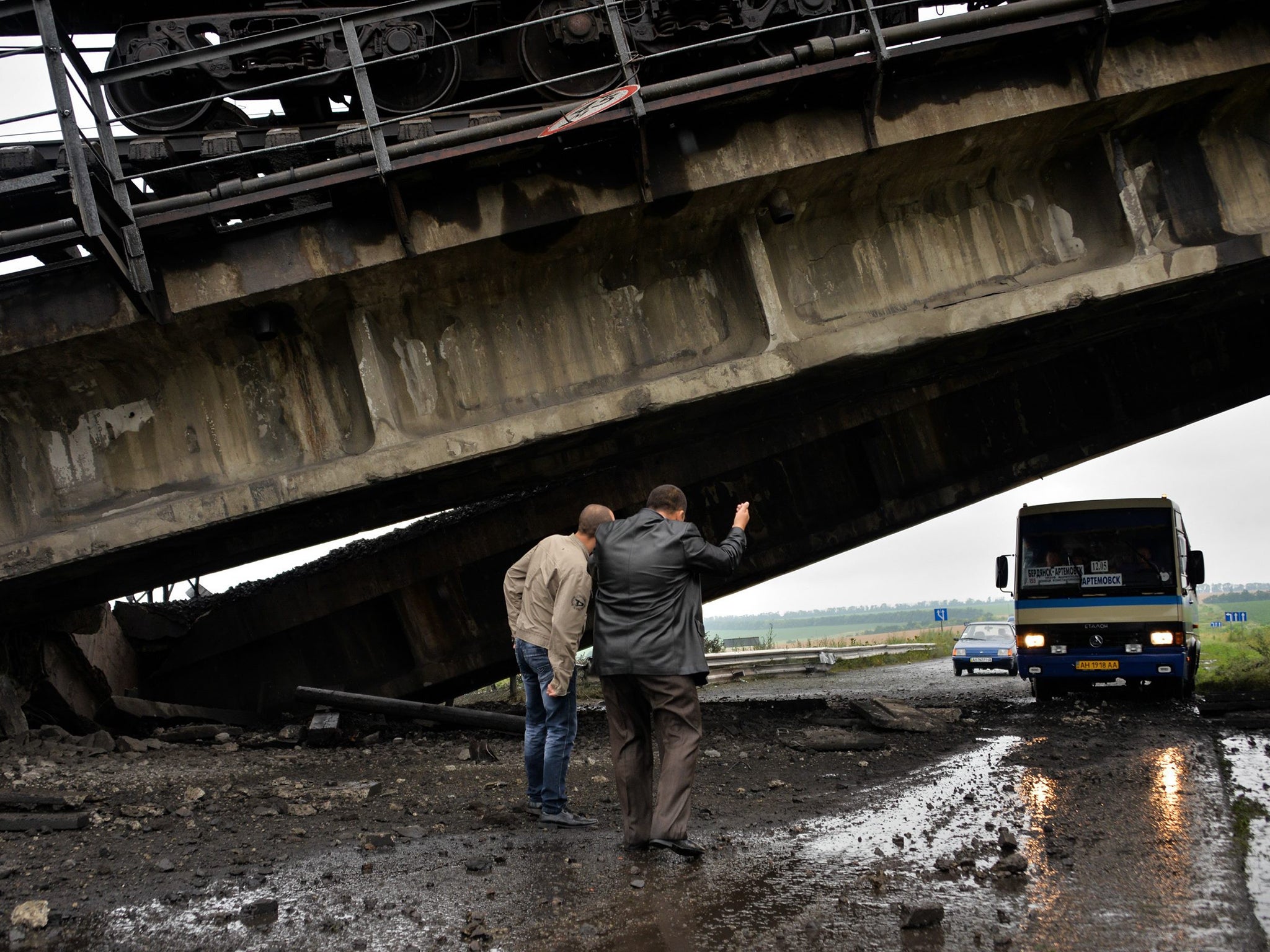 A bus drives under the bridge which was blown up recently by Pro-Russian militants in the near of Donetsk