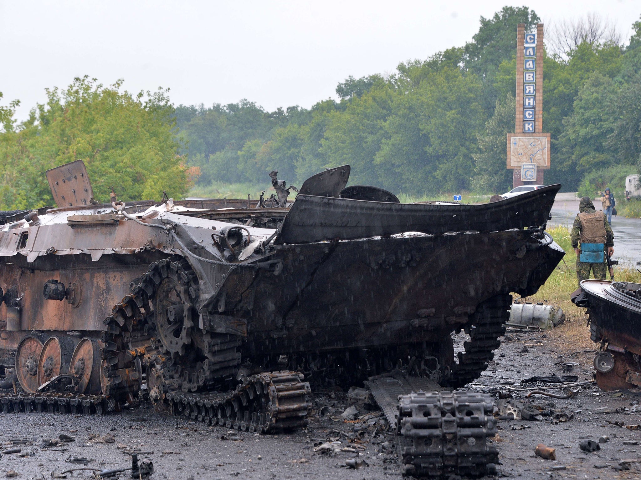 A Ukrainian government soldiers guards wrecked tanks and armored personnel carriers (APCs) left by pro-Russian insurgents in the city of Slavyansk