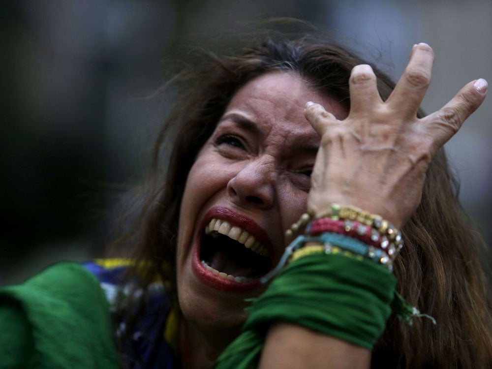 A Brazilian soccer fan cries as she watches her team get beat during a live telecast of the semifinals World Cup soccer match between Brazil and Germany, in Belo Horizonte, Brazil, Tuesday, July 08, 2014.