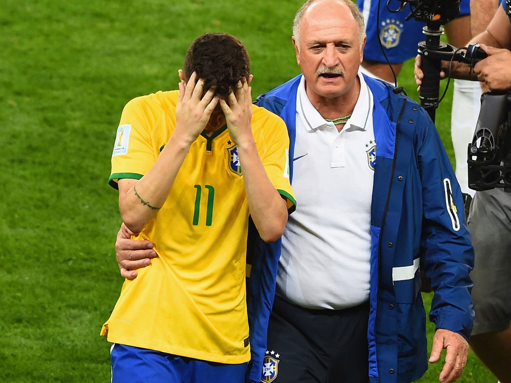 Brazil coach, Luiz Felipe Scolari, consoles his midfielder Oscar after semi-final defeat to Germany (Getty Images)