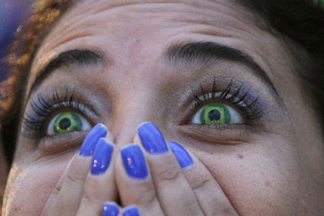 A Brazil fan watches her team lose to Germany in a World Cup semi-final