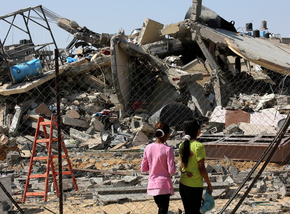 Two Palestinian girls inspect the ruble of a destroyed house following an Israeli airstrike in Rafah refugee camp