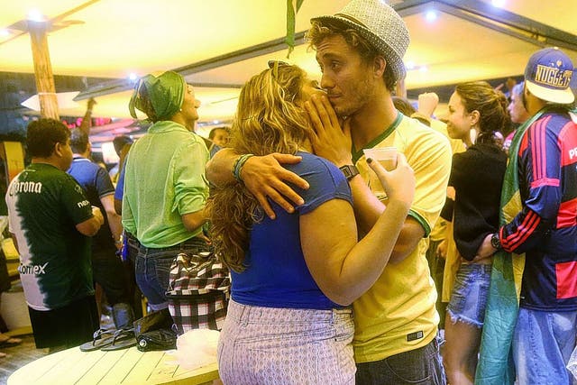 Two Brazilian fans embrace in a bar on Copacabana beach as their country’s humiliating 7-1 defeat by Germany sinks in