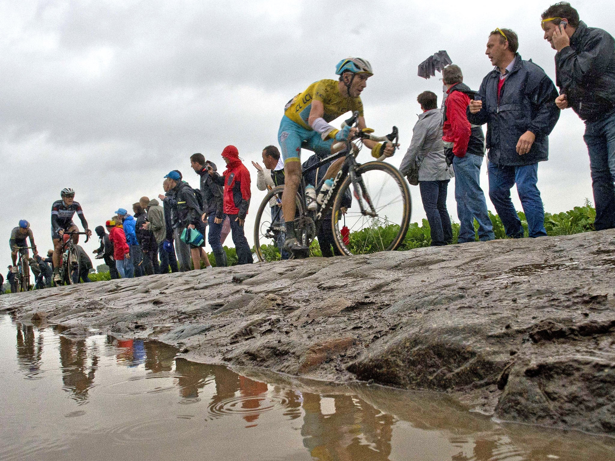 Vincenzo Nibali, wearing the overall leader's yellow jersey, rides through the testing terrain