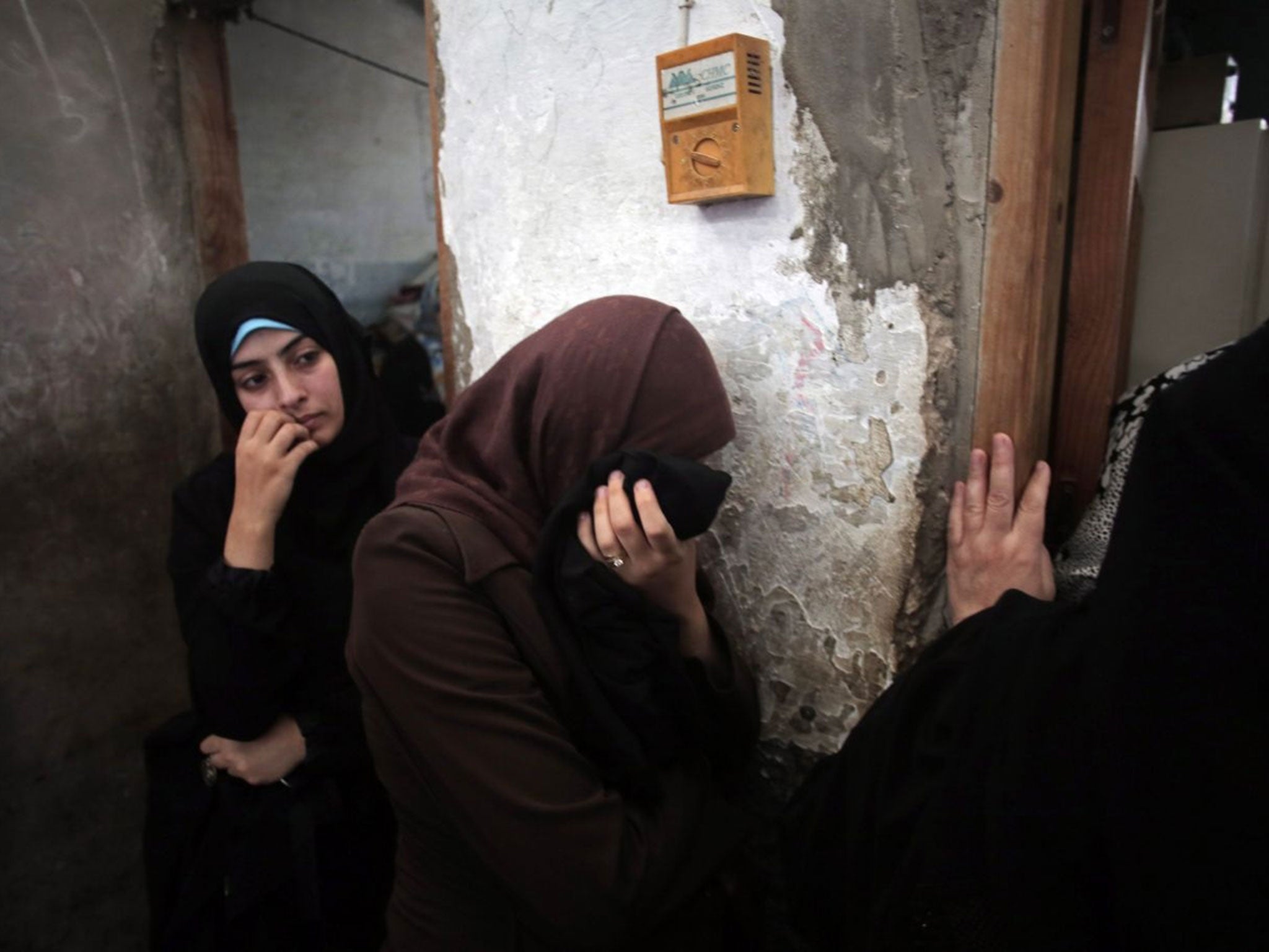 Palestinian relatives of eight members of the Al Haj family grieve in the family house during their funeral in Khan Younis refugee camp (AP)