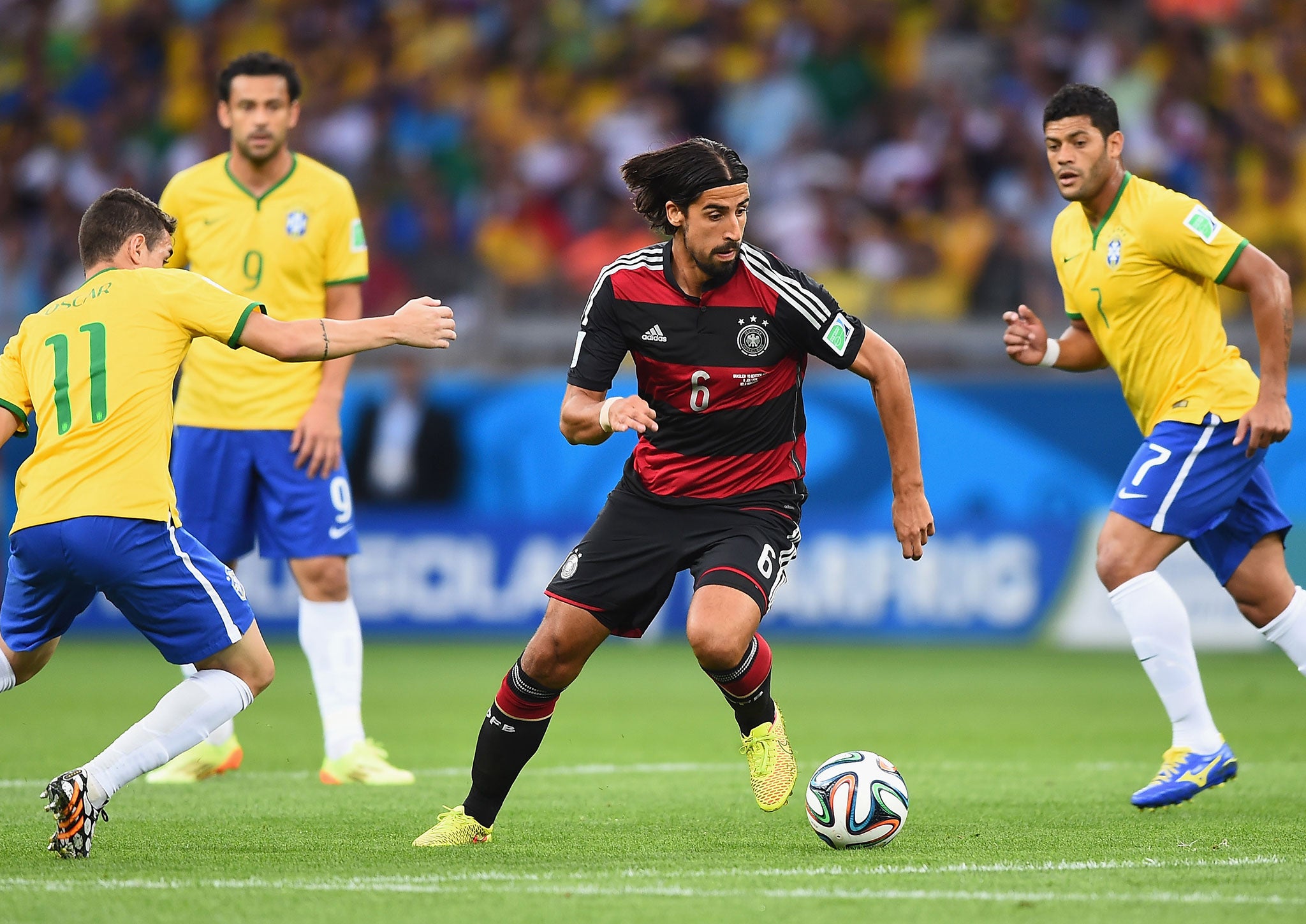 Sami Khedira of Germany runs past Oscar of Brazil with the ball during the 2014 FIFA World Cup Brazil Semi Final match between Brazil and Germany