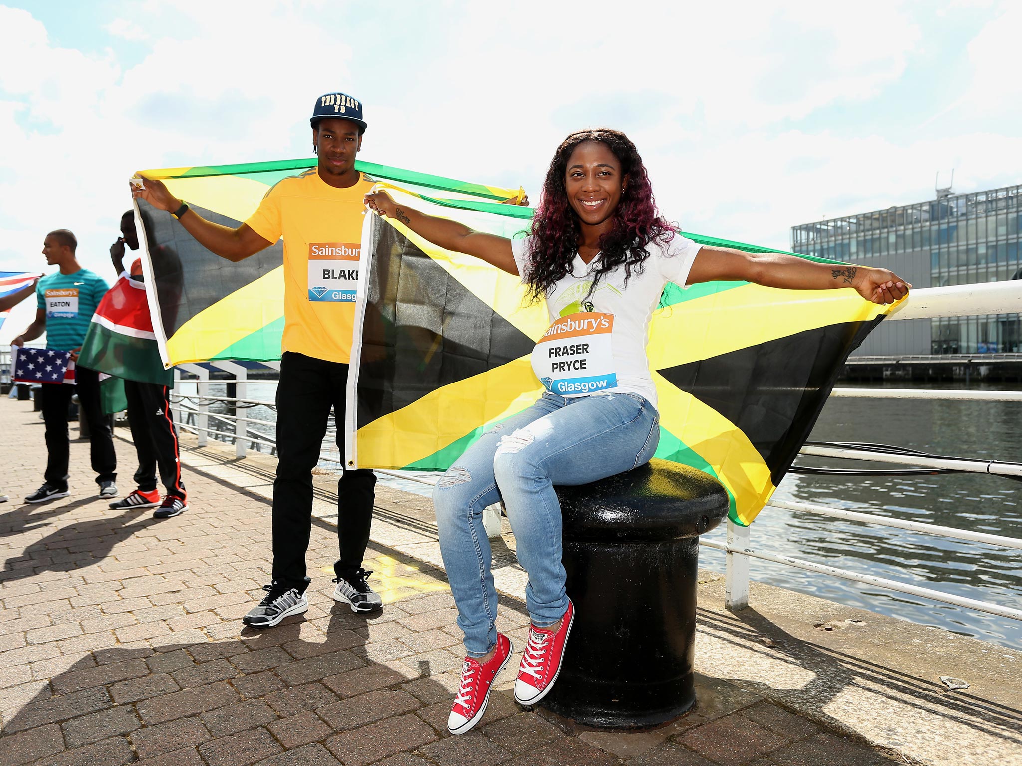 Sprinters Yohan Blake and Shelly-Ann Fraser-Pryce fly the Jamaica flag in Glasgow yesterday