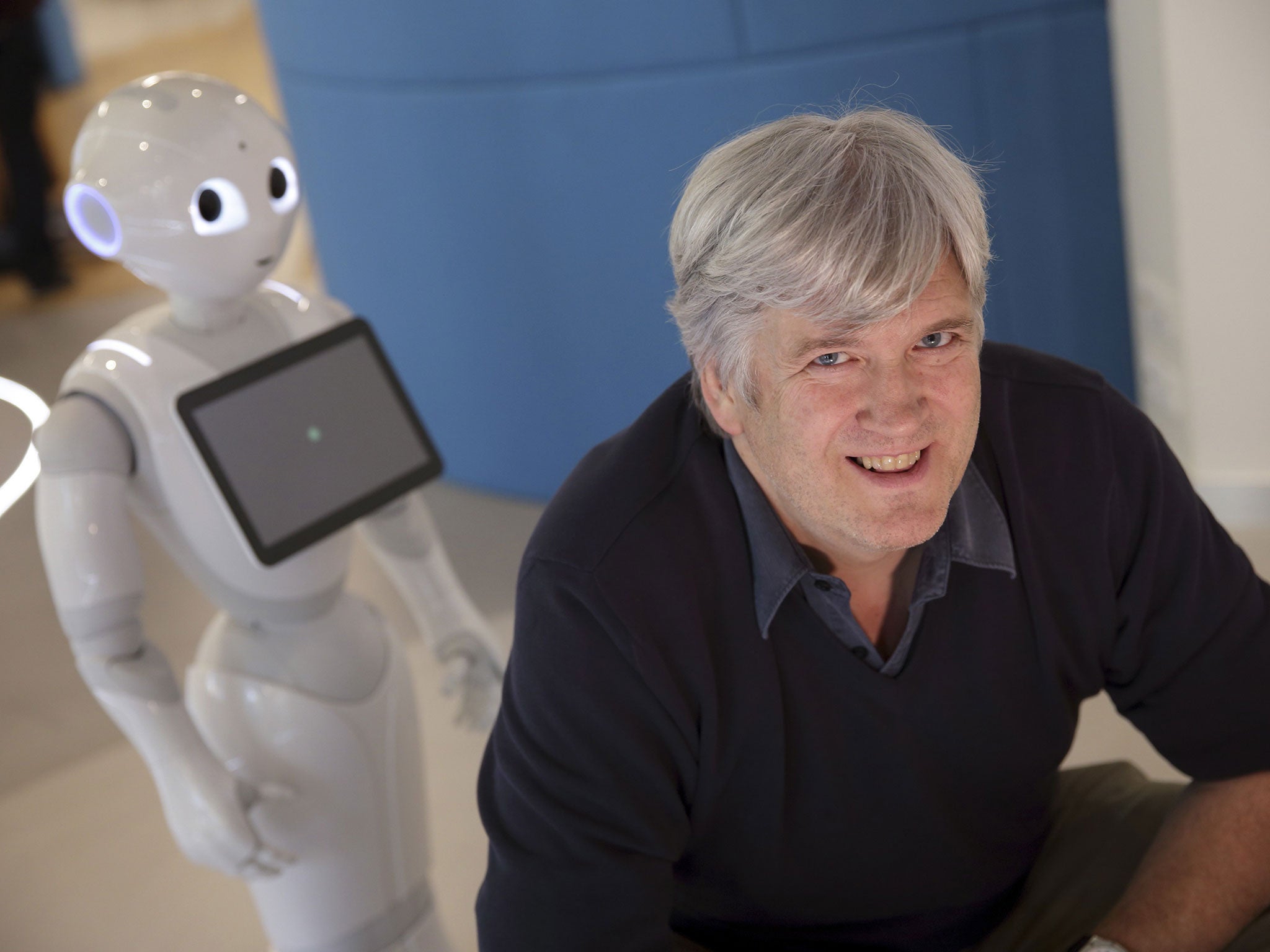 Bruno Maisonnier, CEO and founder of Aldebaran Robotics, poses next to the humanoid robot "Pepper"