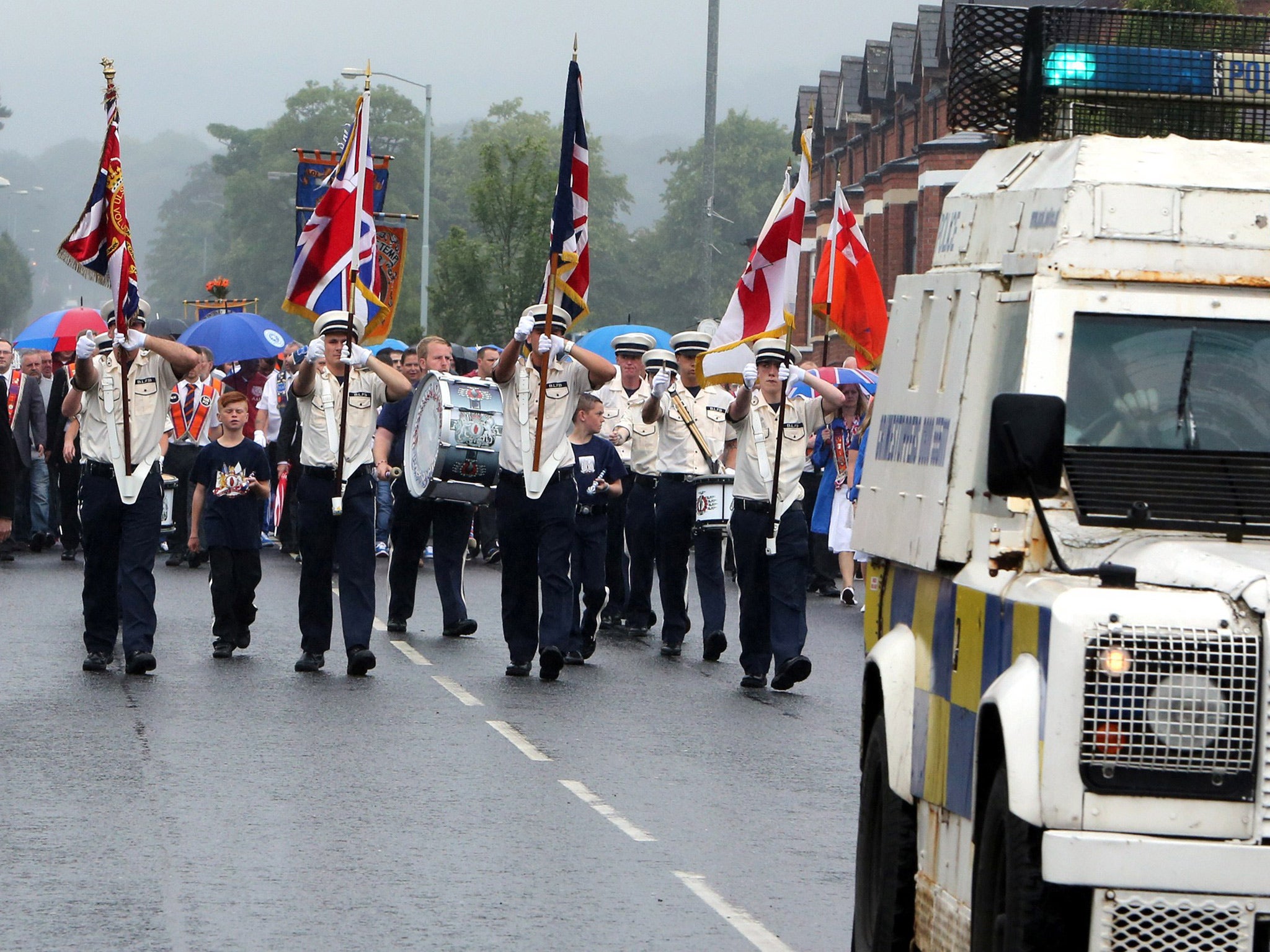 Police escort an Orange Order parade past the nationalist Ardoyne area of North Belfast, in Northern Ireland, on July 12. Source: Getty