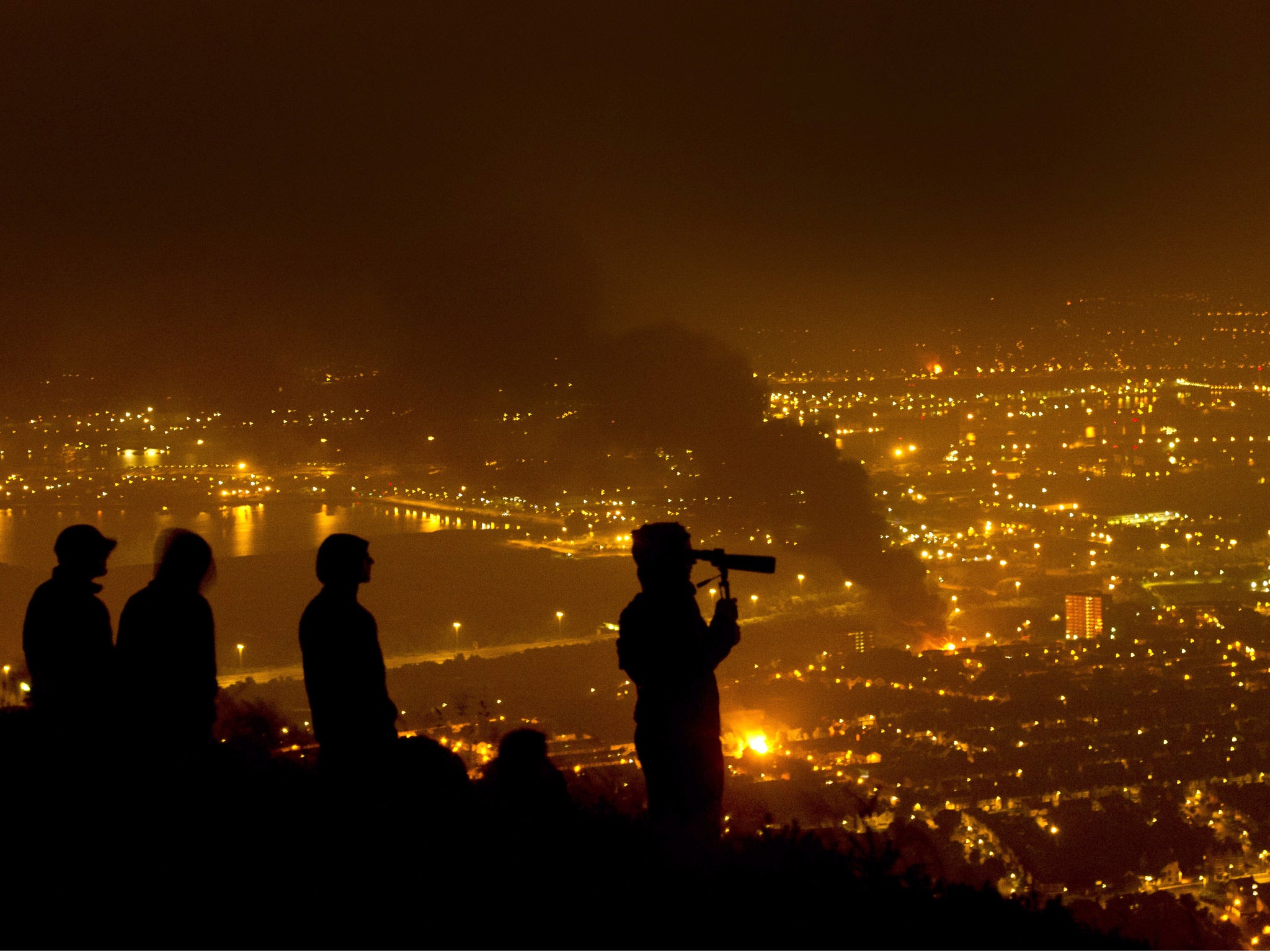 Loyalist youths watch bonfires burning across Belfast from the Cave Hill mountain high above the city July 12, 2014 in Belfast, Northern Ireland.