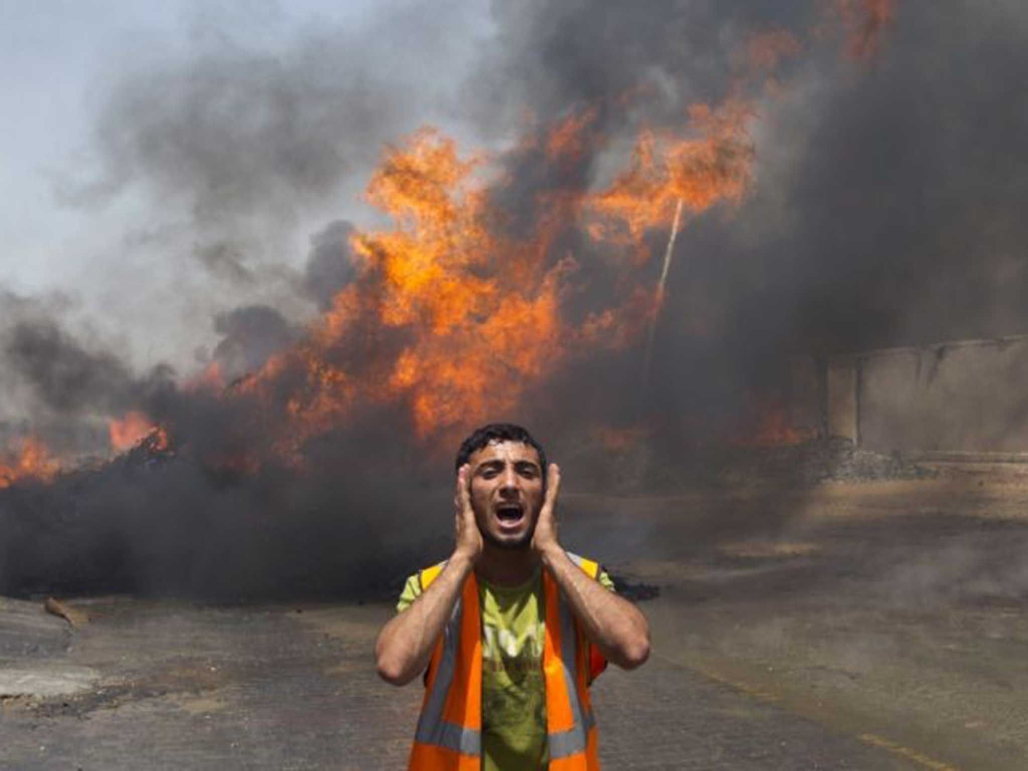 Palestinian firefighters try to extinguish fire at UN storehouse