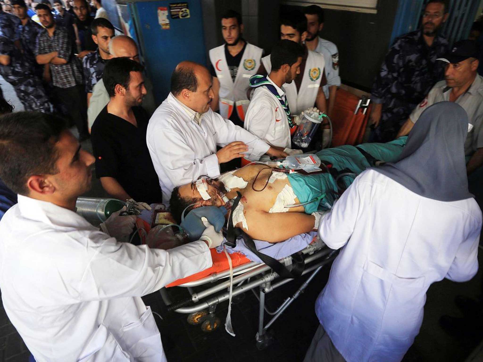 Doctors at Al‑Shifa hospital in Gaza City attempt to treat victims of Israeli air strikes