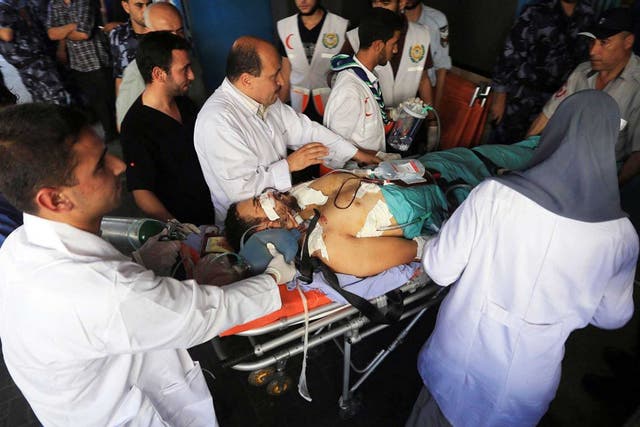 Doctors at Al‑Shifa hospital in Gaza City attempt to treat victims of Israeli air strikes 