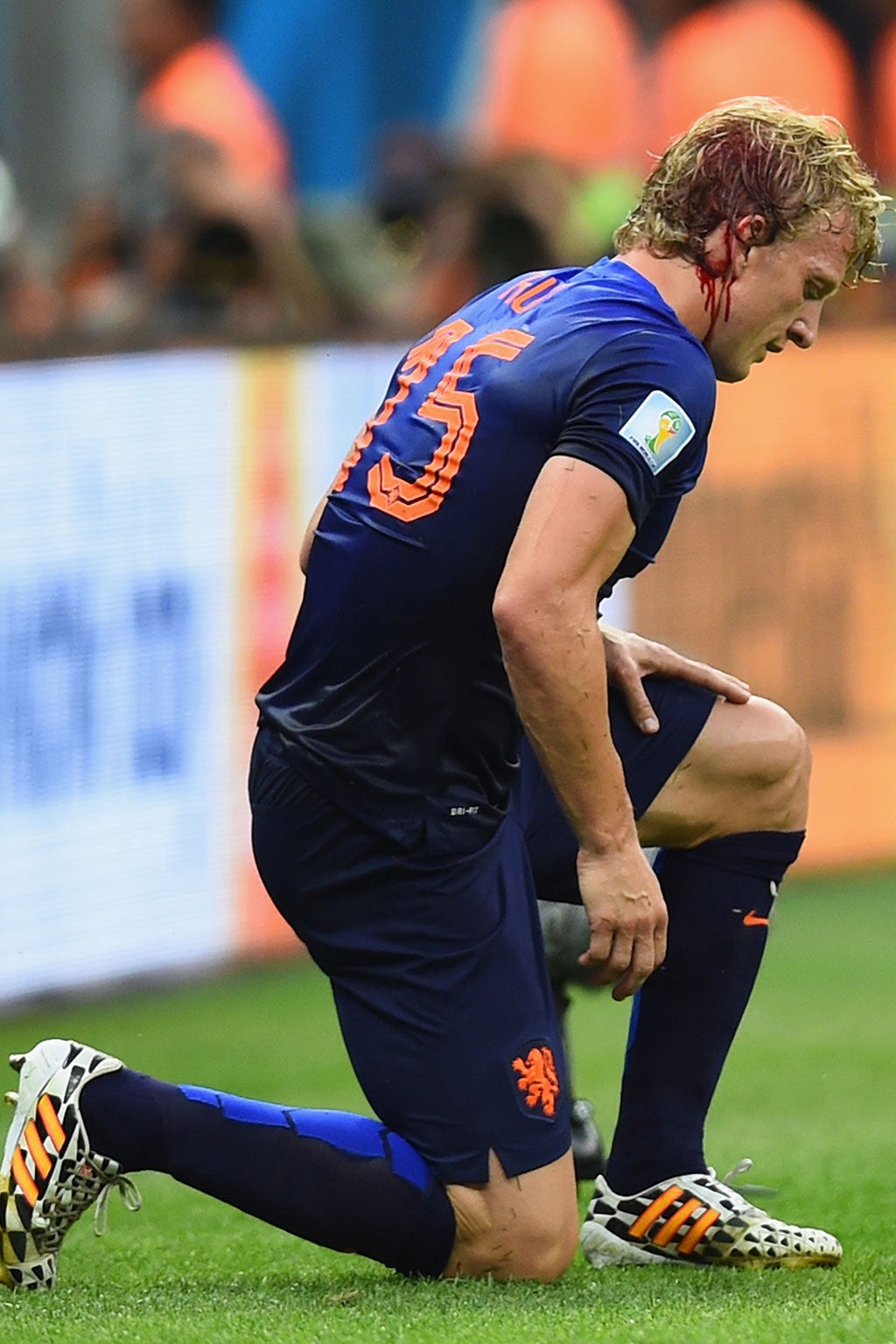 Kuyt is left bloodied after clashing heads with Maxwell of Brazil