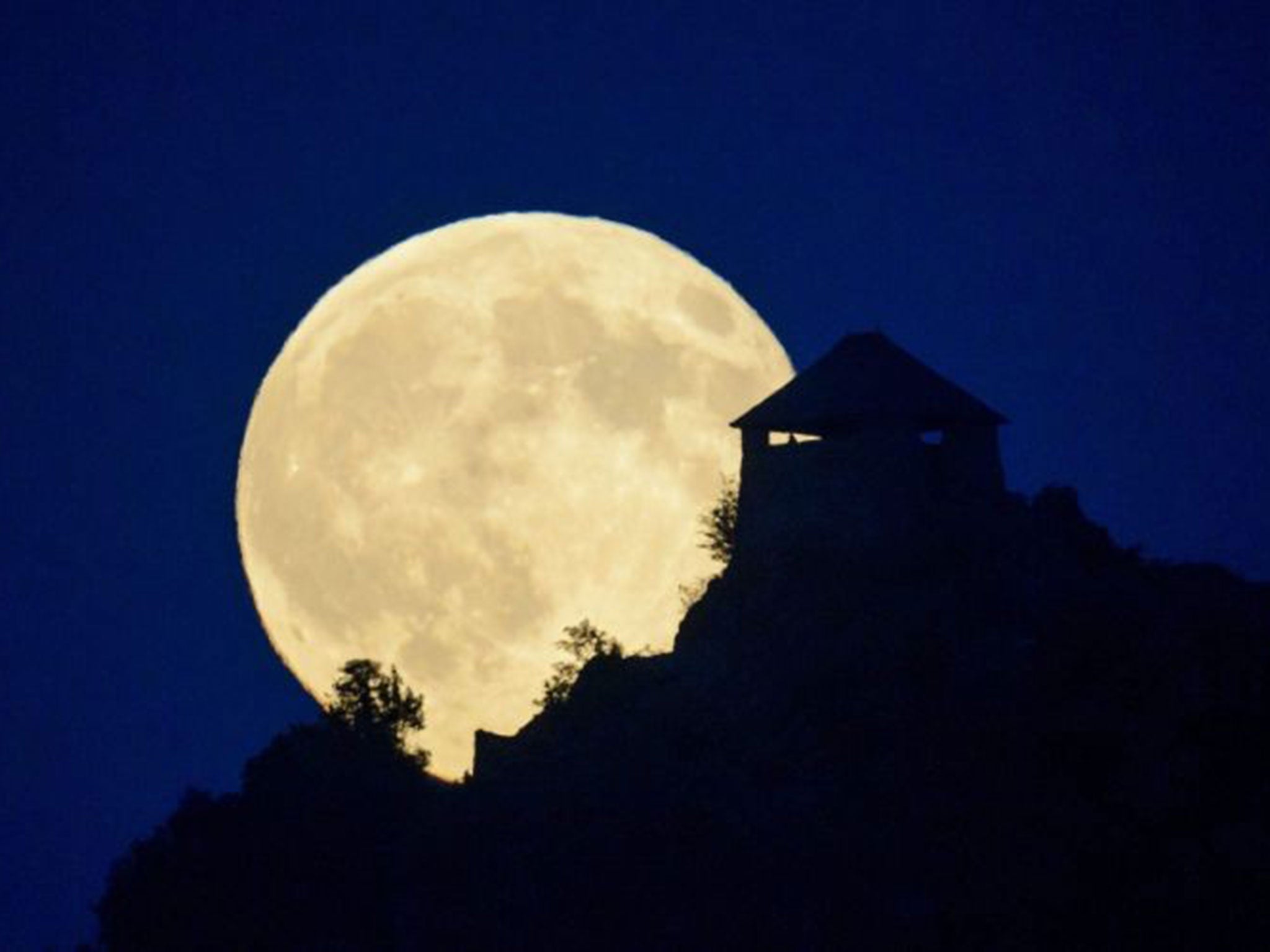 The supermoon shines behind the castle of Somoskoujfalu in Hungary