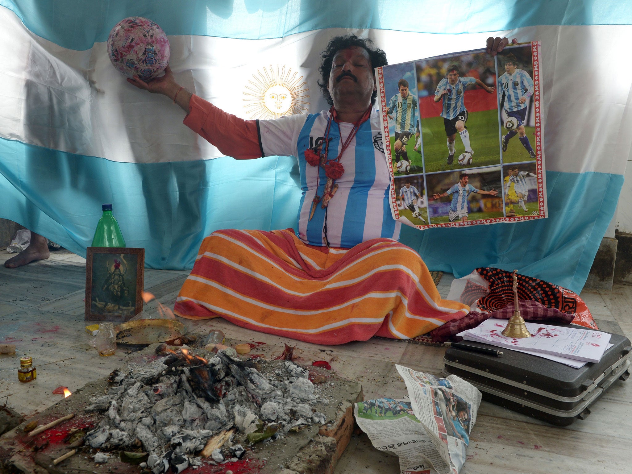 An Indian Hindu priest performs rituals for the success of the Argentina team