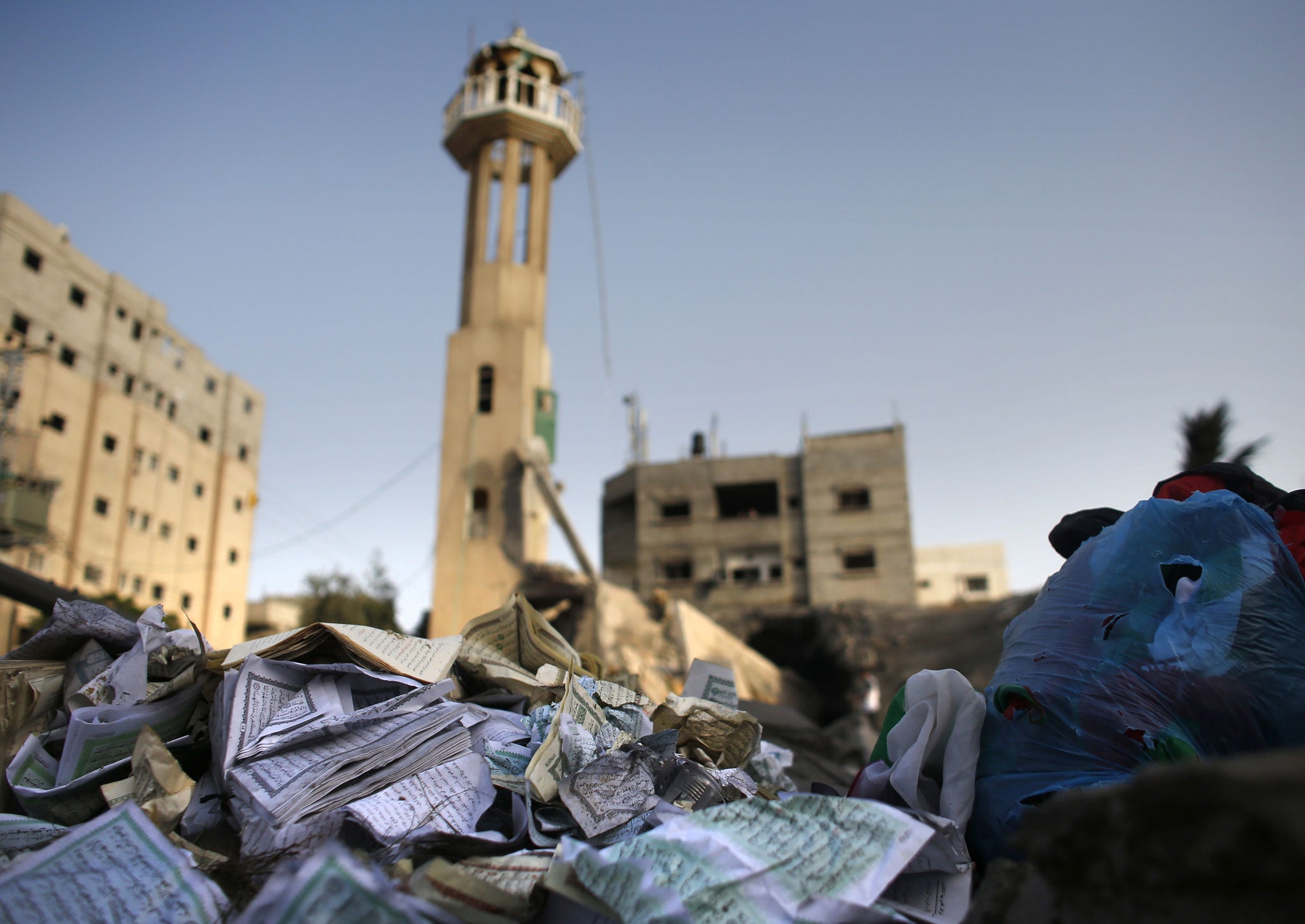 Damaged copies of Islam's holy book the Koran lie on the rubble from a destroyed mosque following an Israeli military strike in the Nusseirat refugee camp in the central Gaza Strip