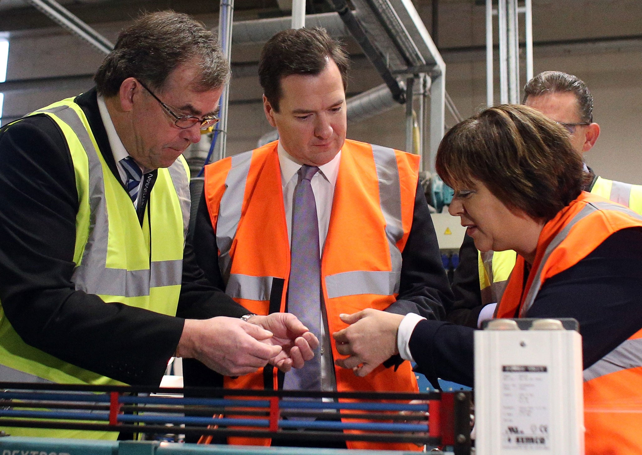 Chancellor George Osborne (C) wears a high visibility jacket as he makes a visit to the Prysmian Group factory and speaks to factory manager Steve Price