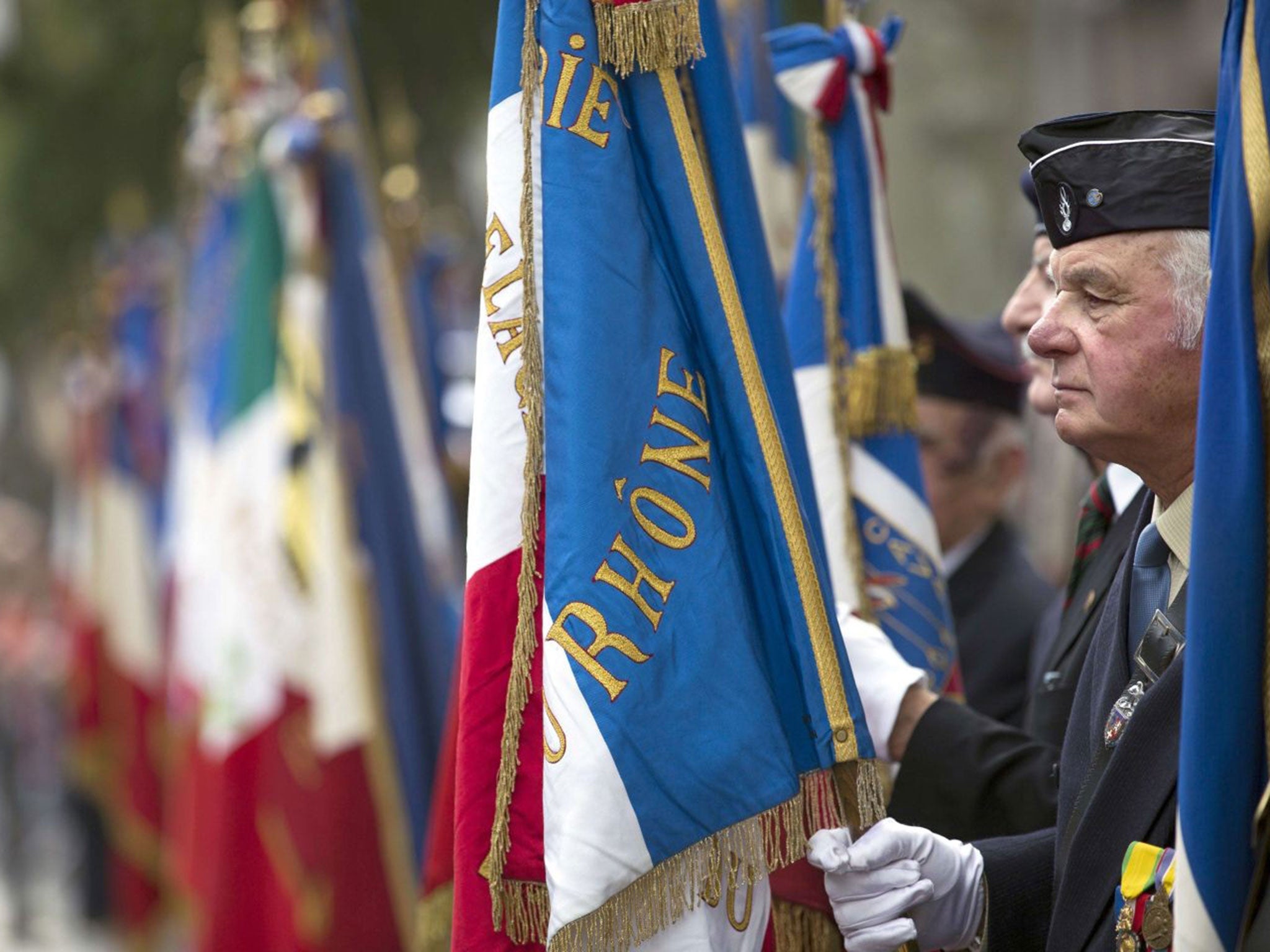 Veterans parade in Lyon on the eve of 14 July celebrations, which have been marred by a row over foreign delegates