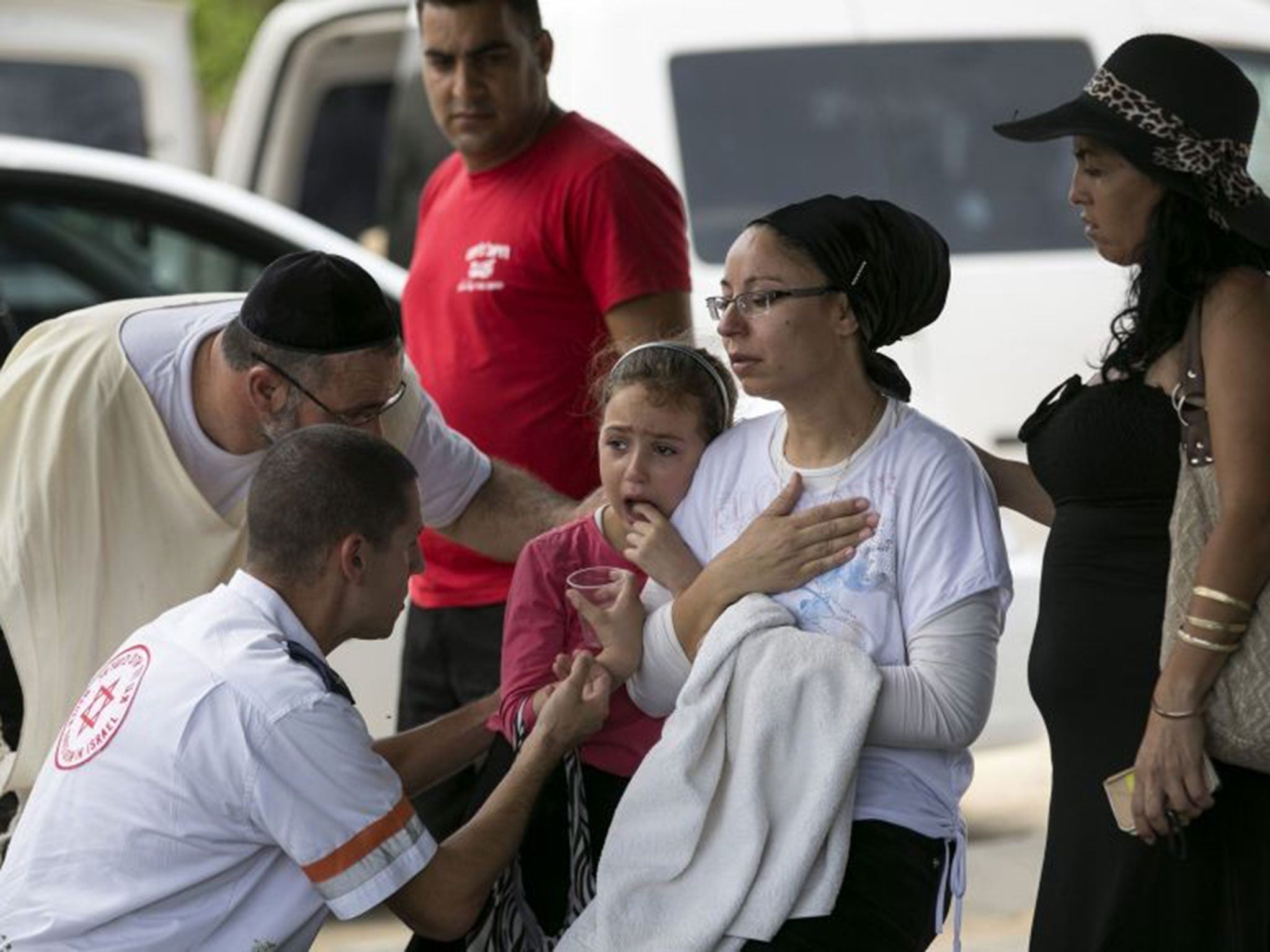 An Israeli mother and daughter are comforted at the scene of a rocket attack in Ashkelon yesterday