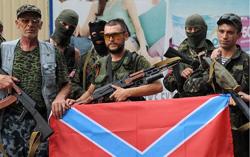 Pro-Russian militants pose on July 13, 2014 with the new Russia flag in Donetsk, eastern Ukraine