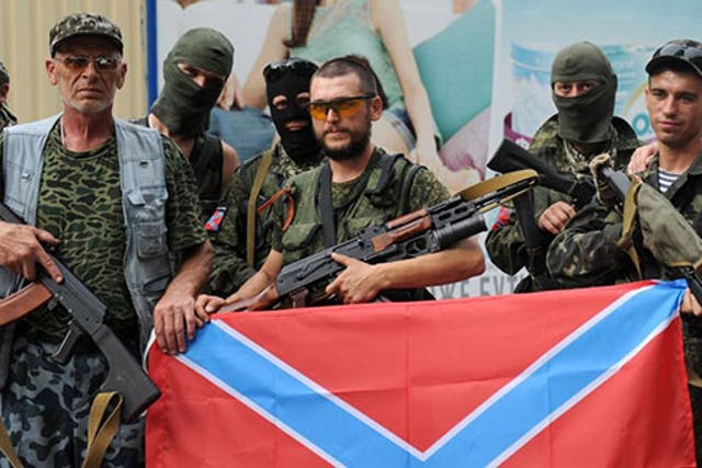 Pro-Russian militants pose on July 13, 2014 with the new Russia flag in Donetsk, eastern Ukraine