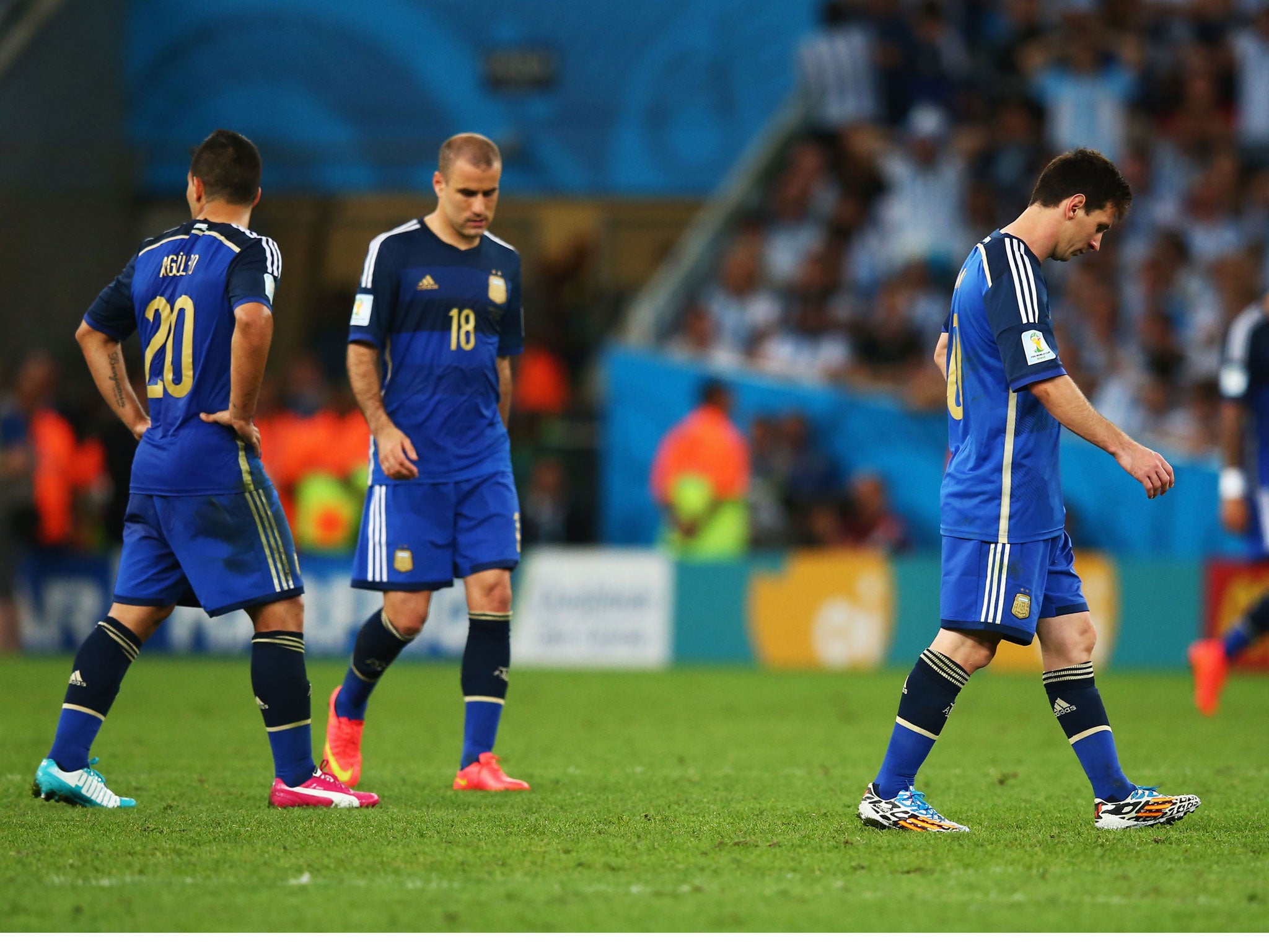 Lionel Messi, Sergio Aguero and Rodrigo Palacio trudge after the pitch after the World Cup final