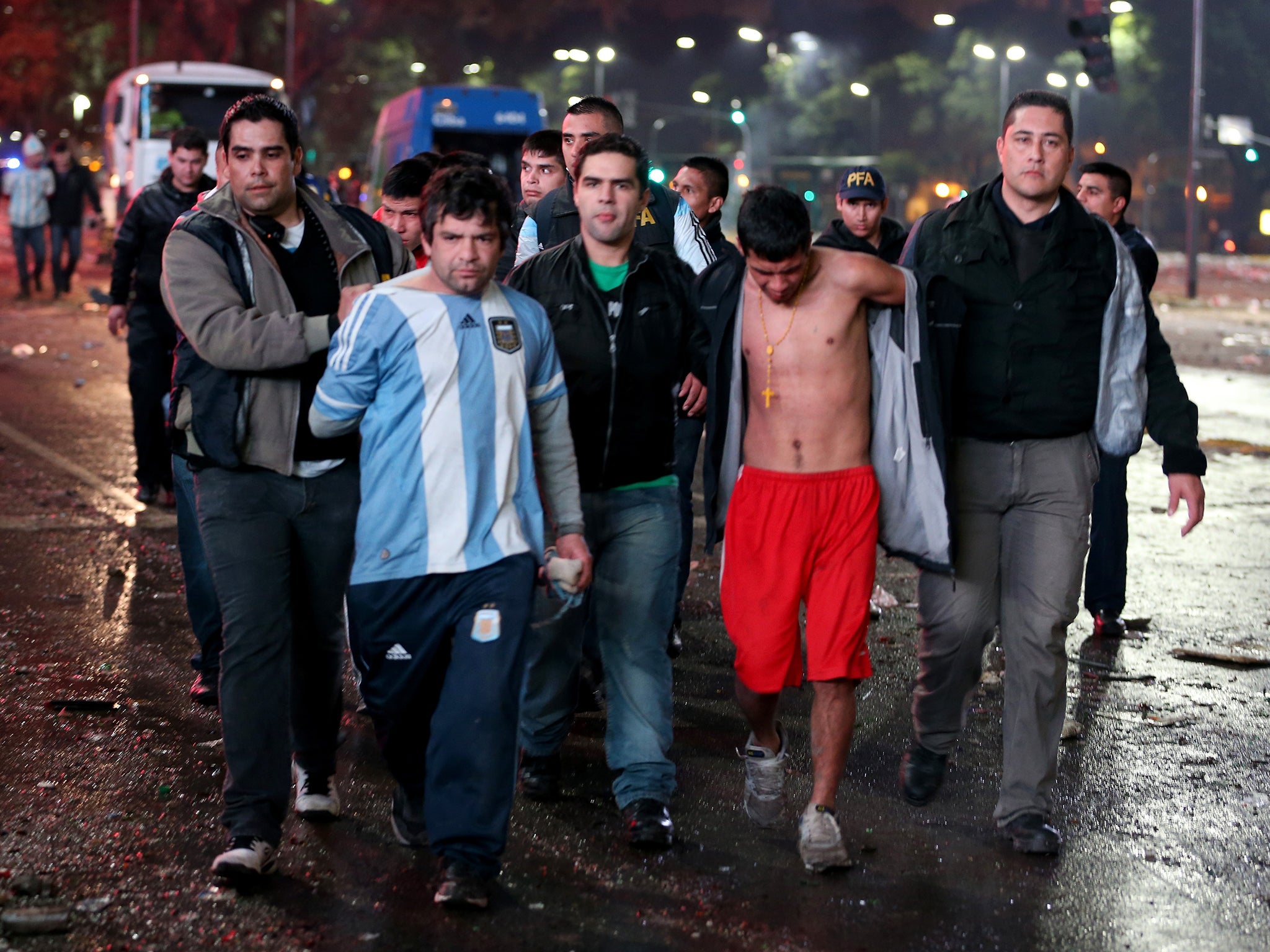 Police officers detain Argentine soccer fans caught after violence erupted near the Obelisco de Buenos Aires after their team lost to Germany 1-0 during the World Cup final in Buenos Aires