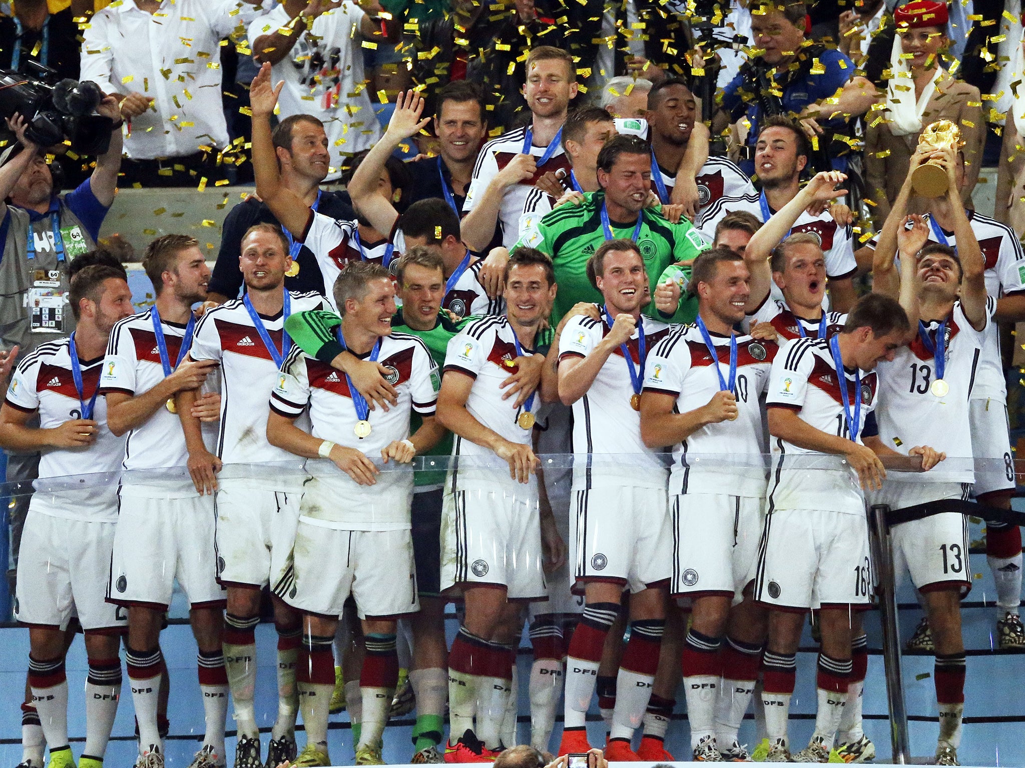 Germany's Thomas Mueller (R) lifts the trophy beside his teammates after the World Cup final soccer match between Germany and Argentina at the Maracana Stadium in Rio de Janeiro, Brazil
