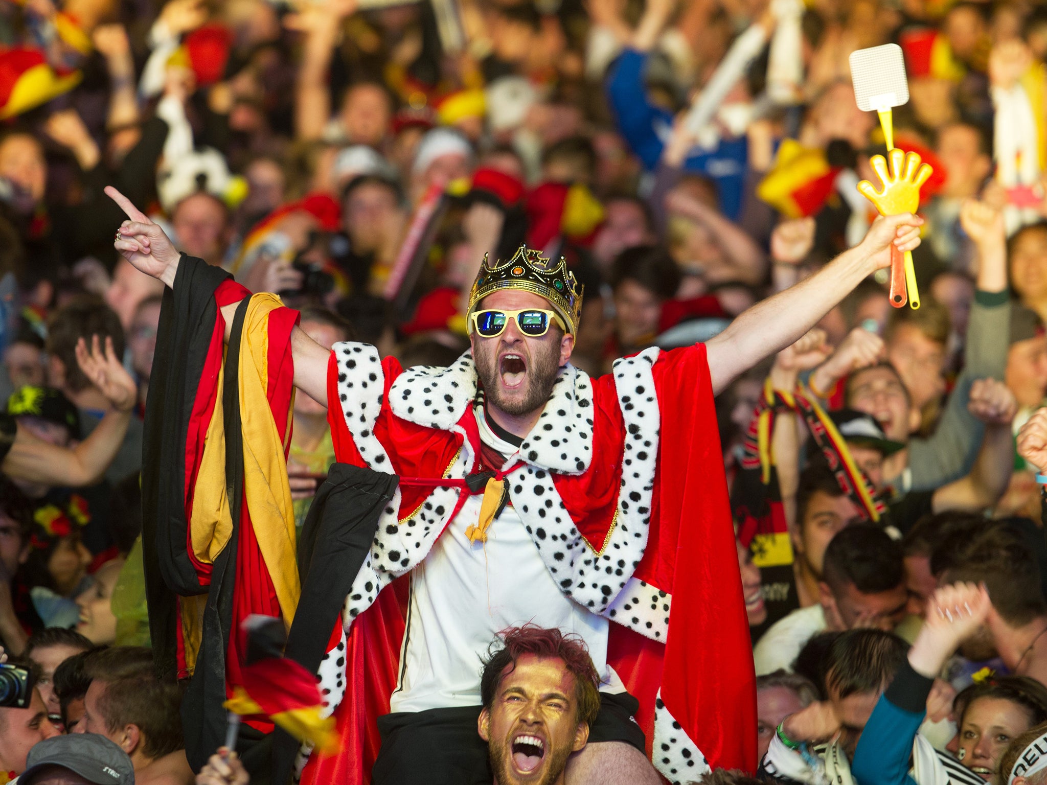 German soccer fans react after the deciding goal for Germany in the final of the Brazil World Cup 2014 between Germany and Argentina played in Rio de Janeiro, Brazil, at a public viewing area called 'Fan Mile' in Berlin