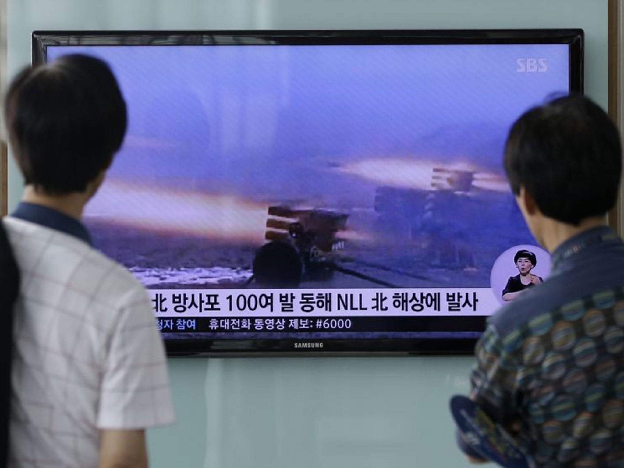 People watch a TV news programme reporting on North Korea's artillery shells at Seoul Railway Station in Seoul, South Korea,on Monday 14 July, 2014