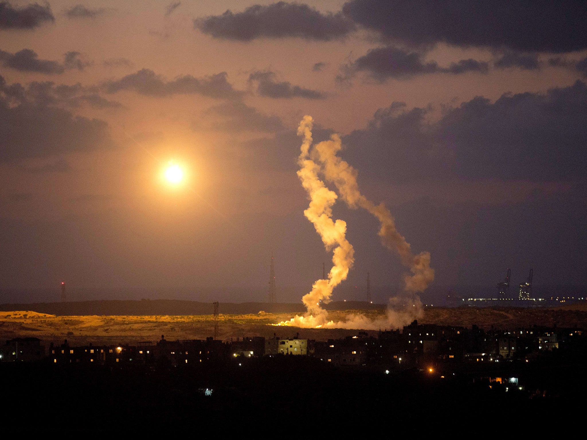 A photo taken from the southern Israeli Gaza border shows Israeli army flares falling into the Palestinian enclave. Israel's security cabinet was to meet early on July 15 to discuss Egyptian proposals for a truce in Gaza, a senior official said, as an aer